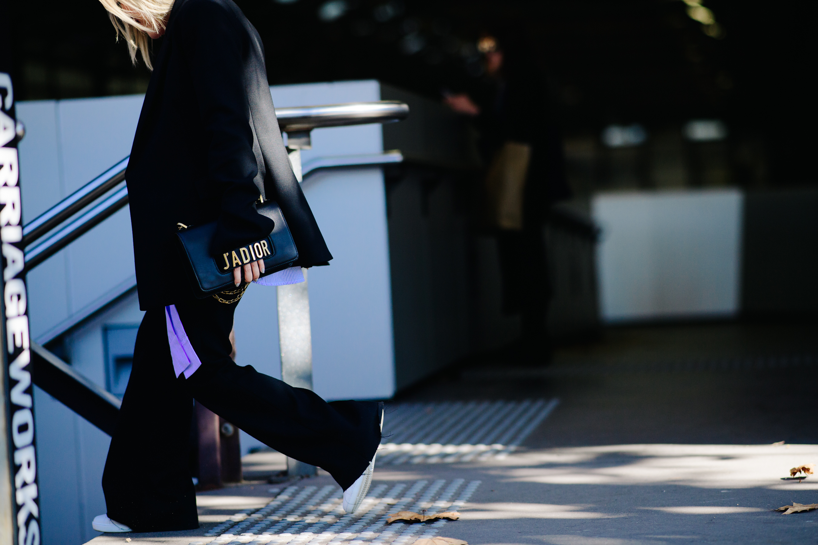 Woman carrying a Dior clutch
