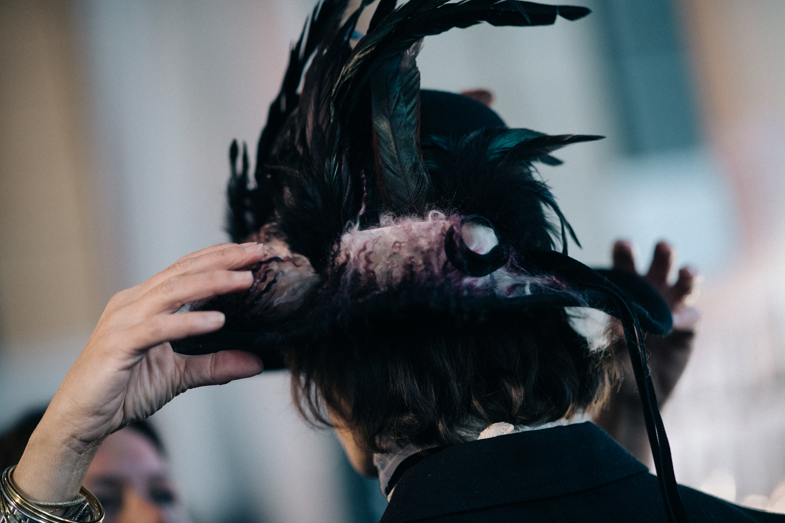 Model wearing big hat with feathers