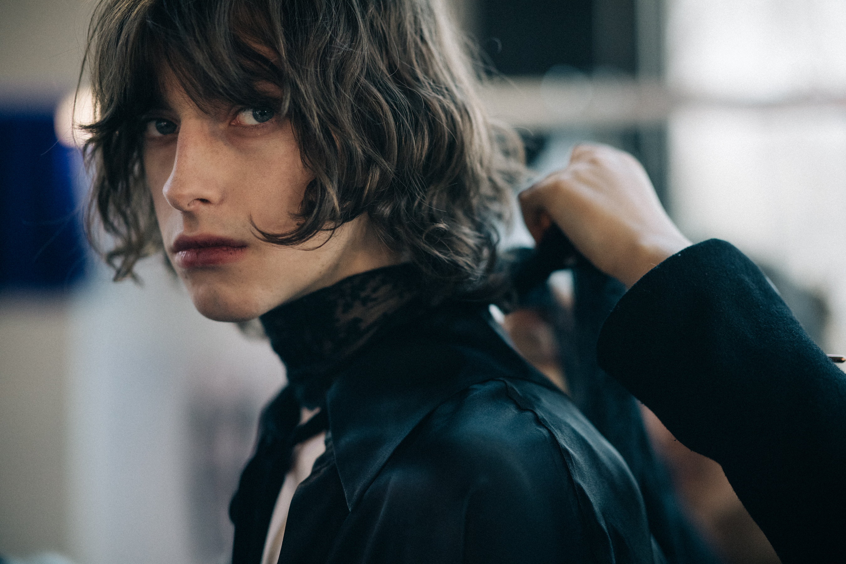 Male model getting dressed in black