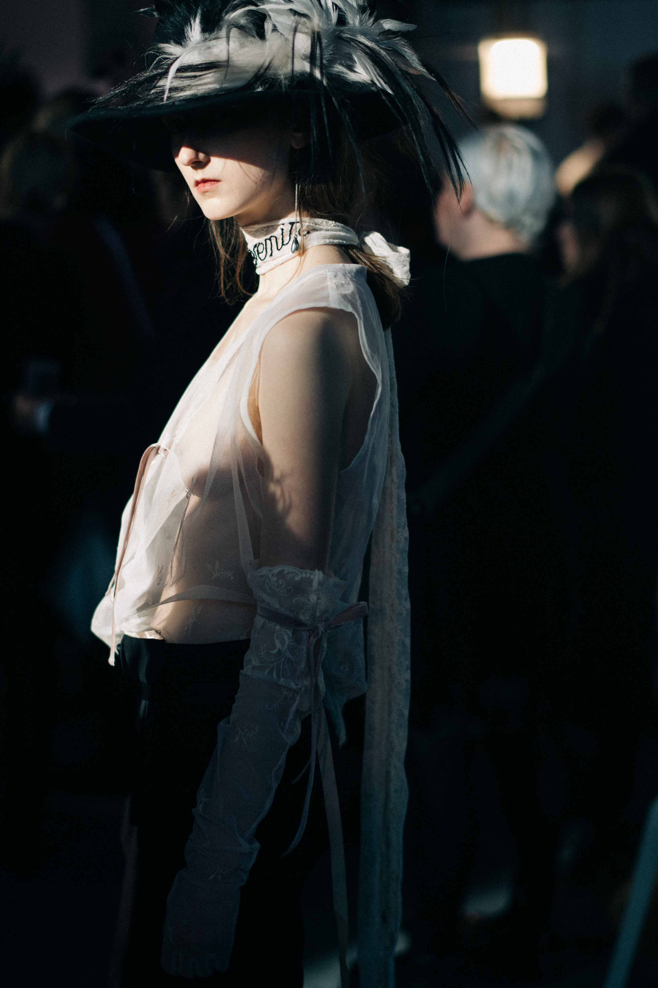 Model wearing hat with feathers