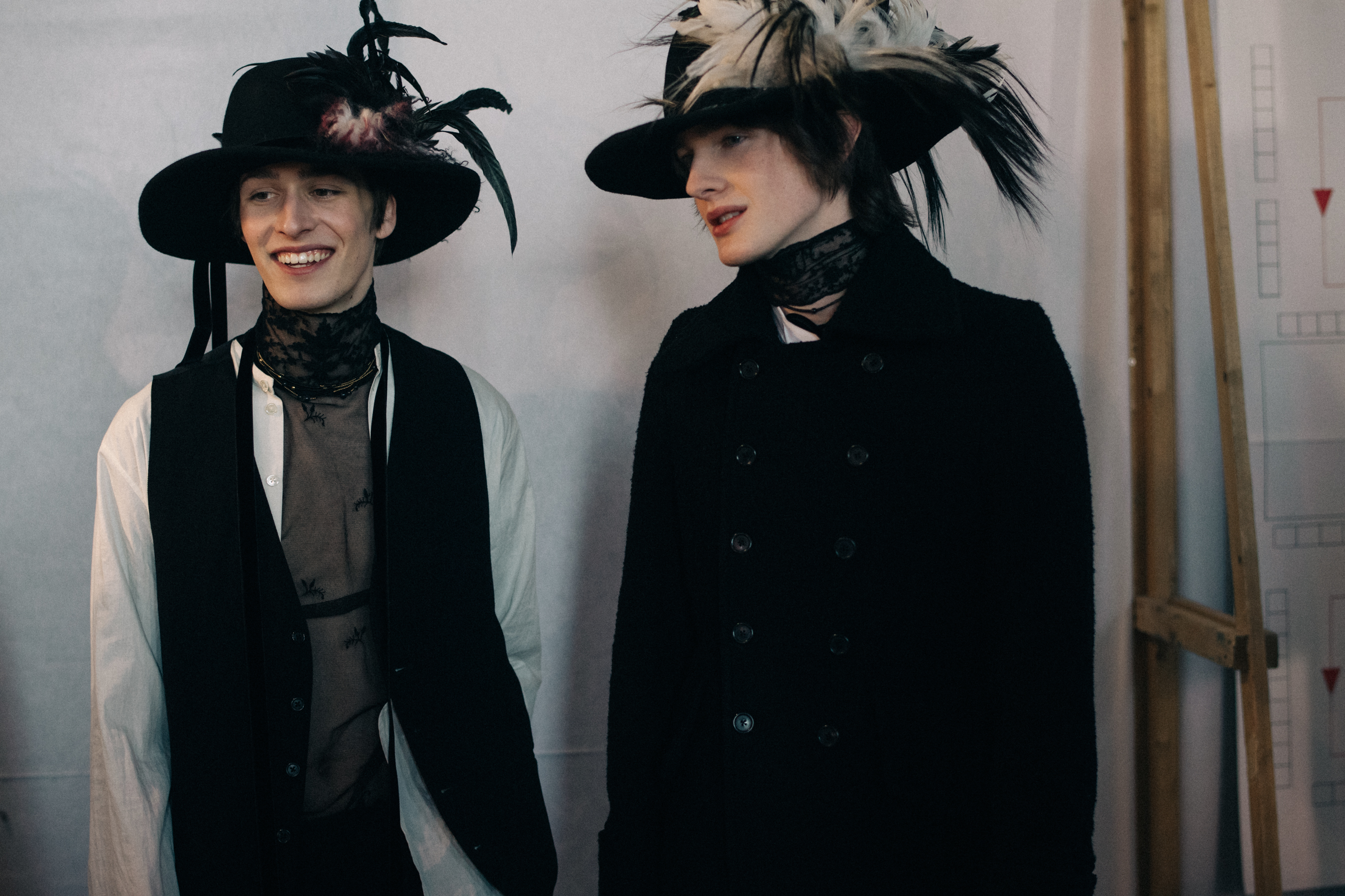 Male models wearing feather hats