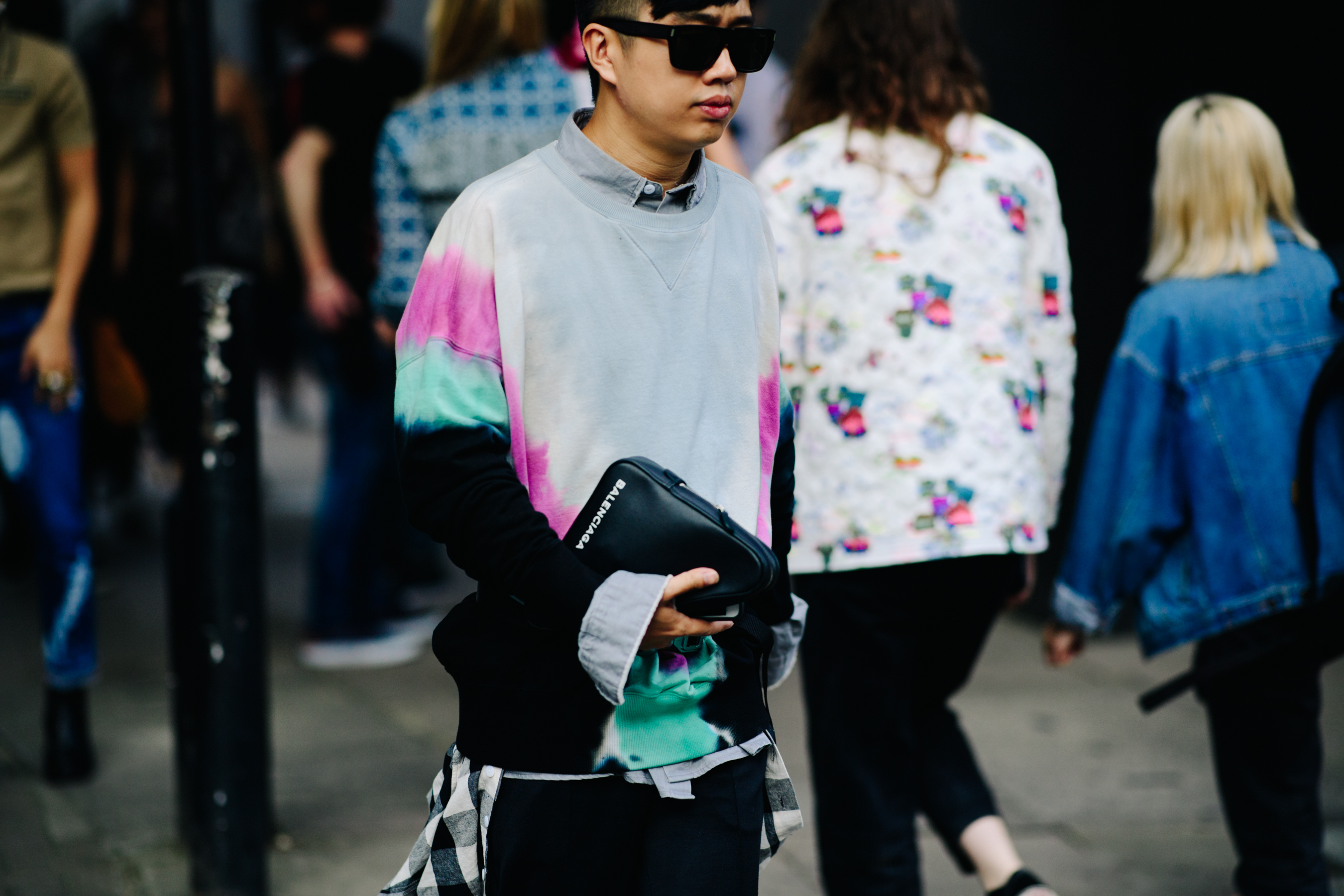 Boy carrying a Balenciaga clutch