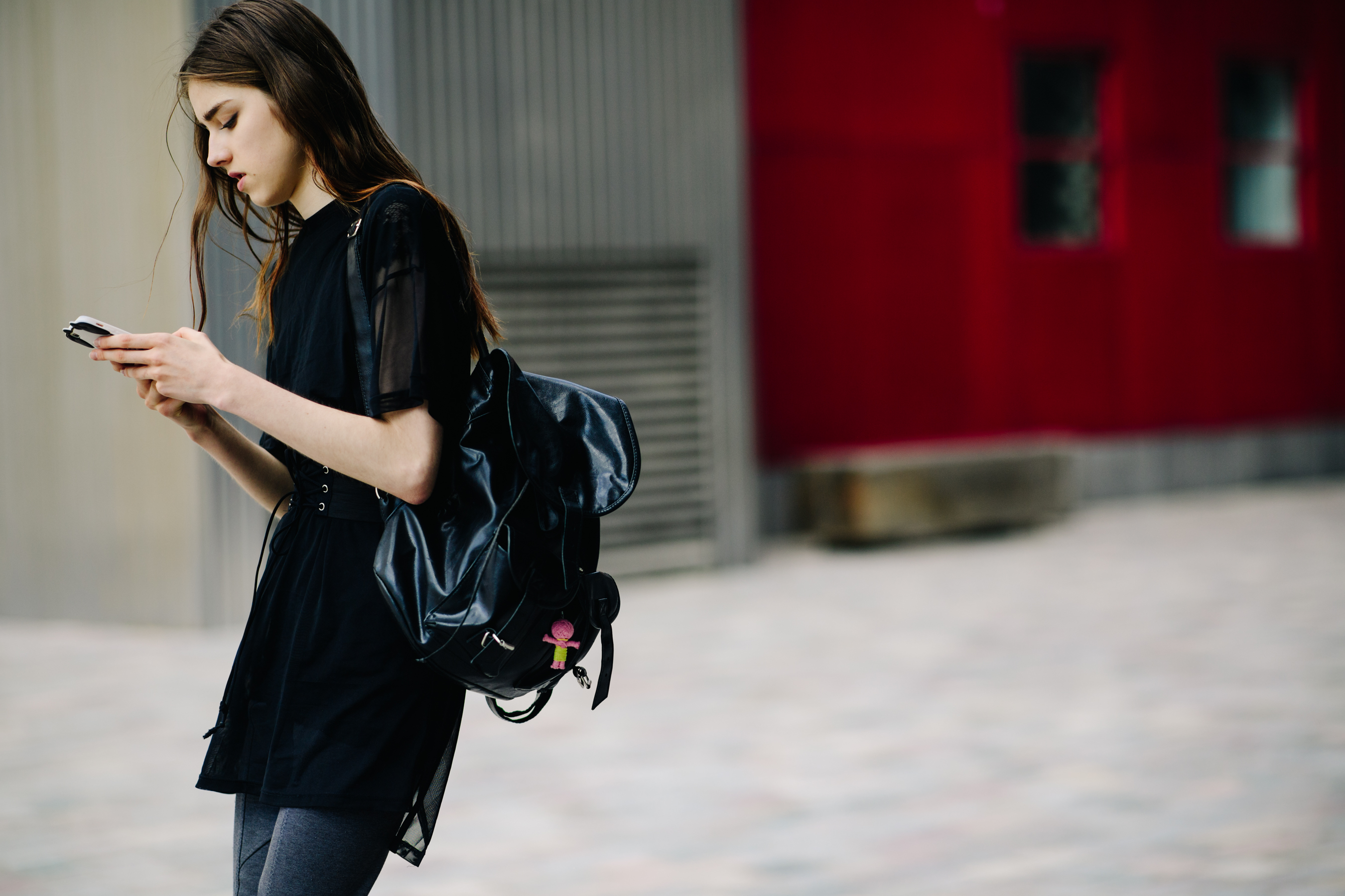 Model carrying a black leather bag