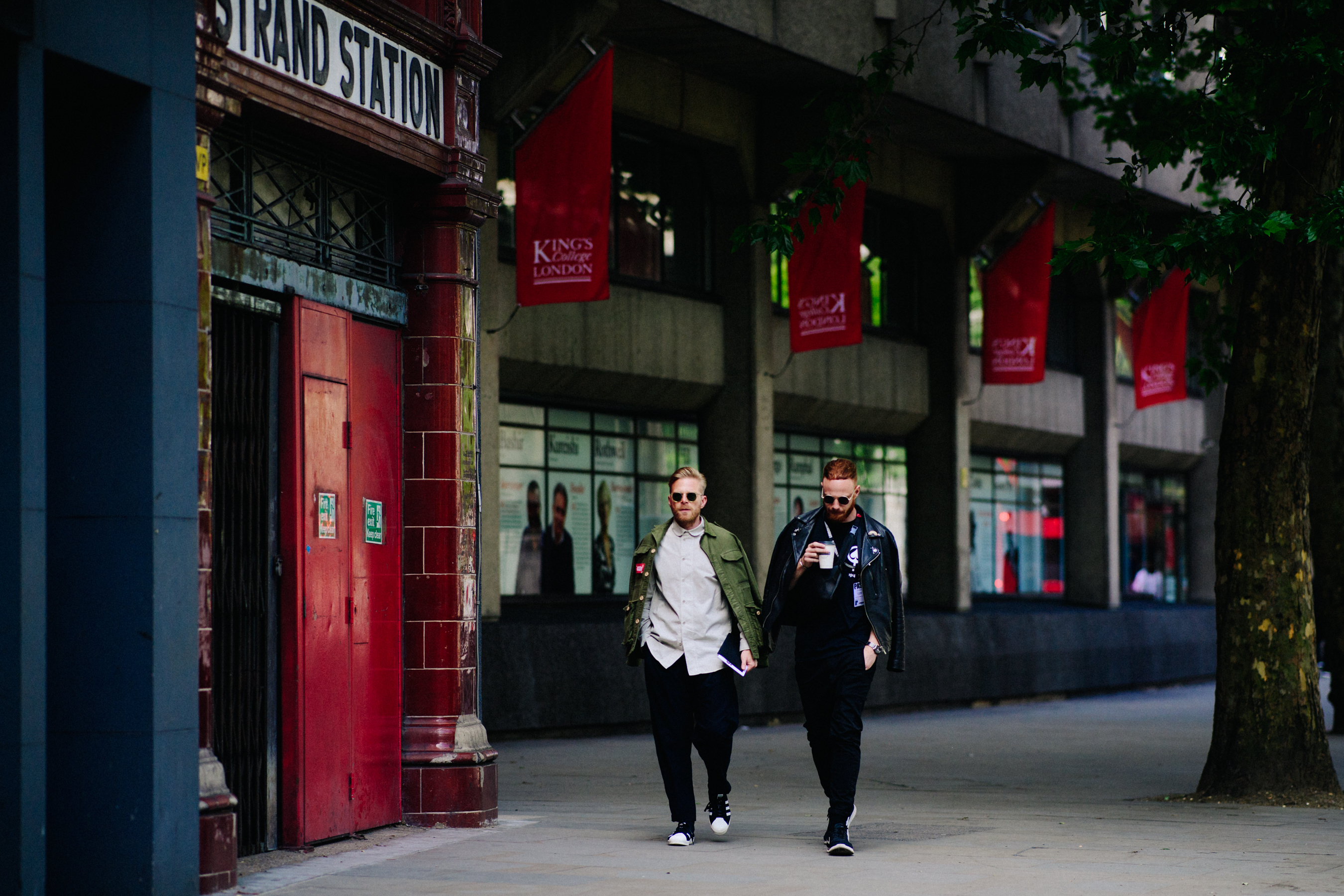 Two men wearing black adidas shoes