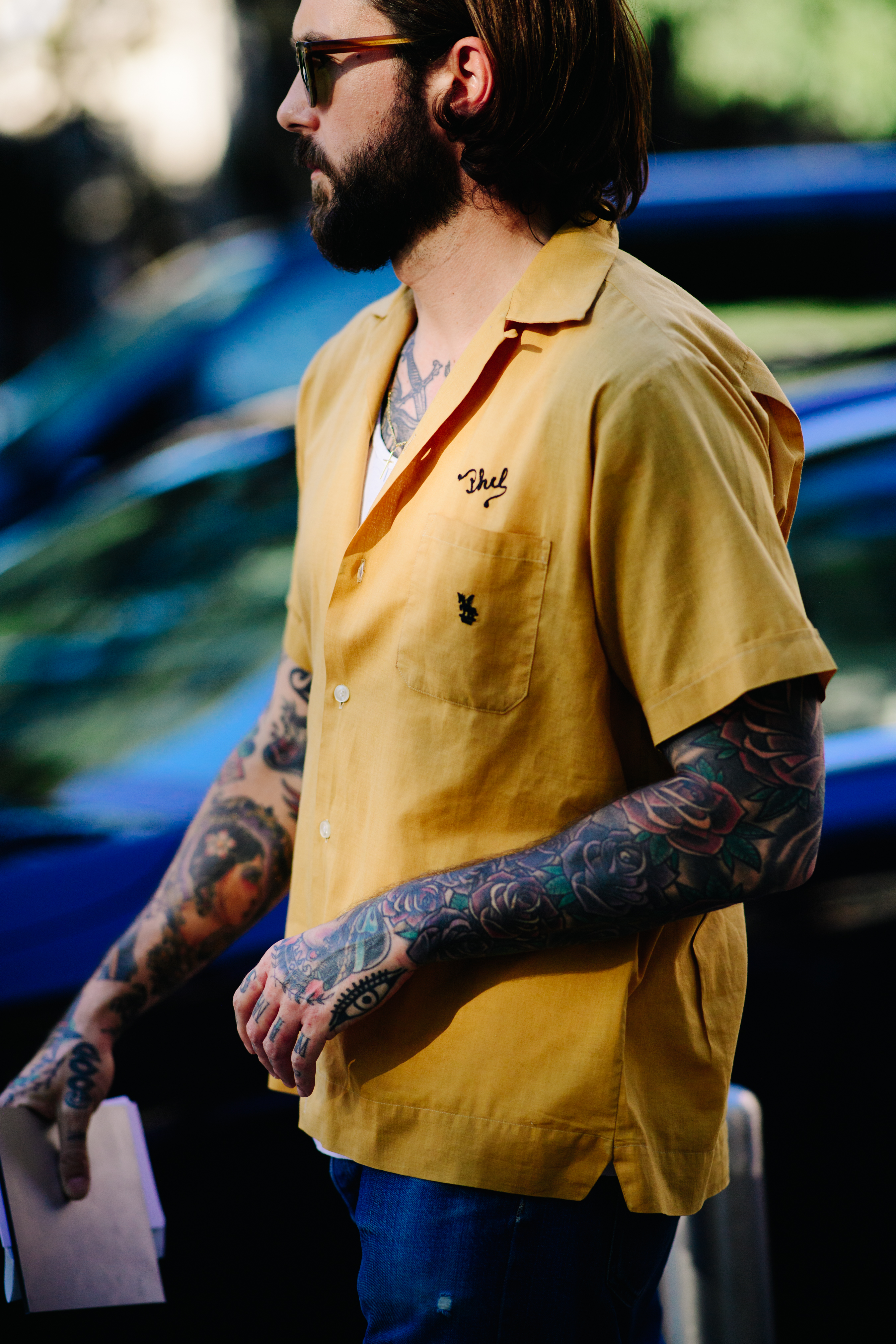 Tattooed man wearing a yellow shirt