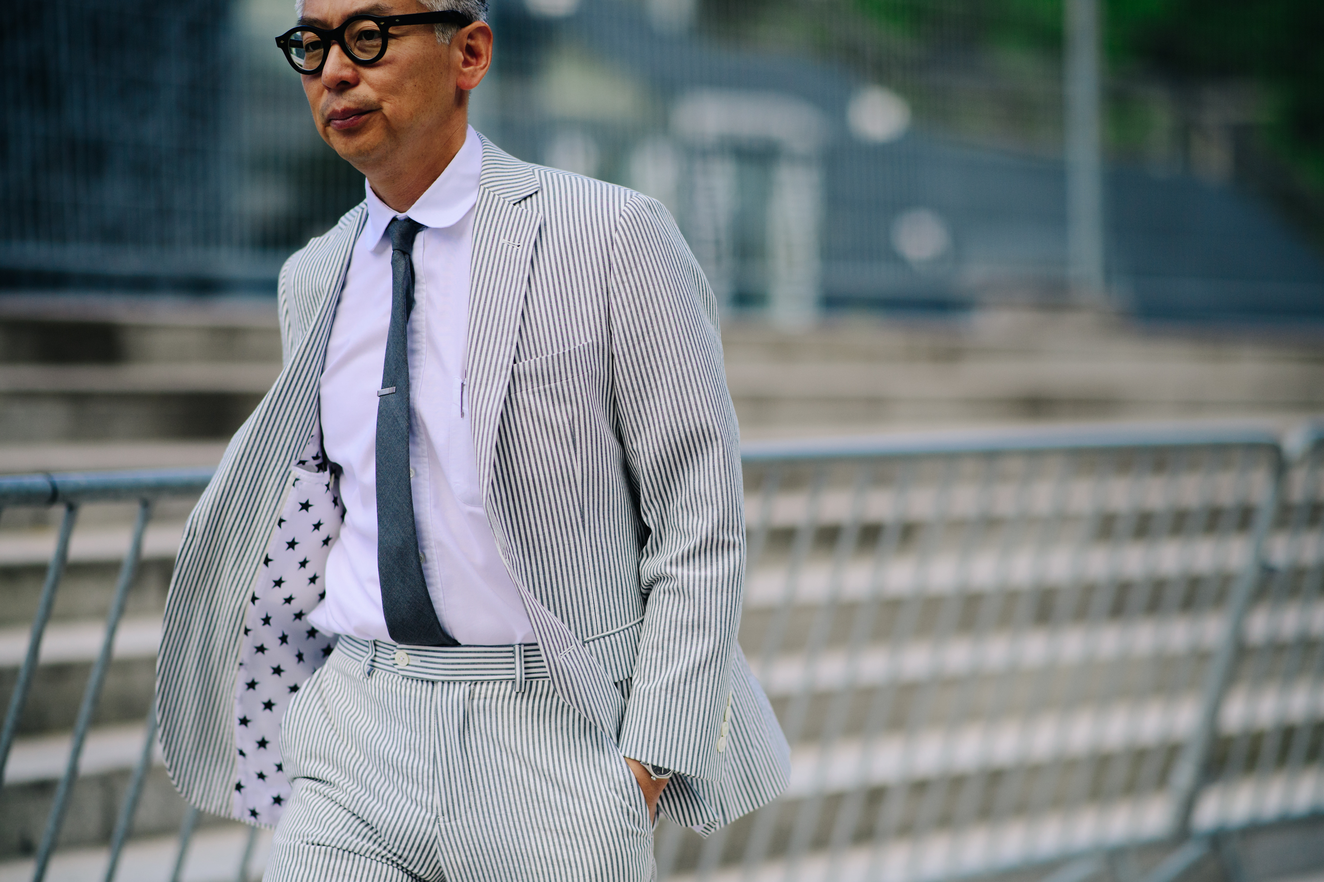 Japanese designer wearing a striped suit
