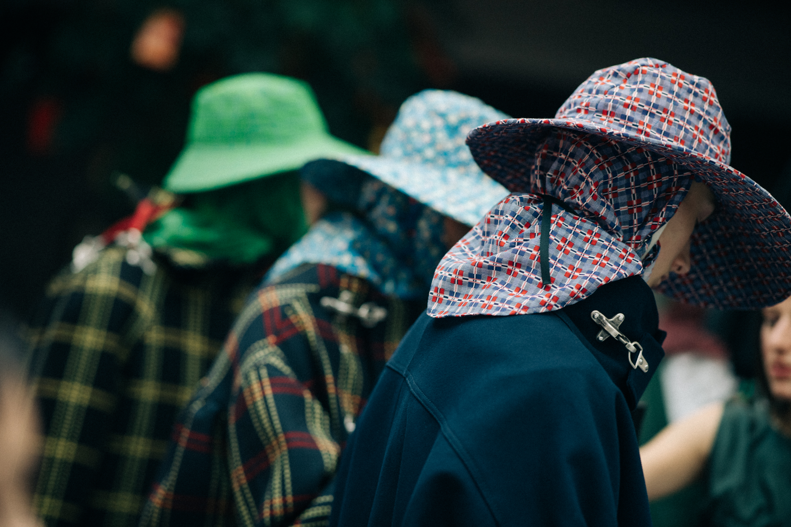 Male models wearing colorful rain hats