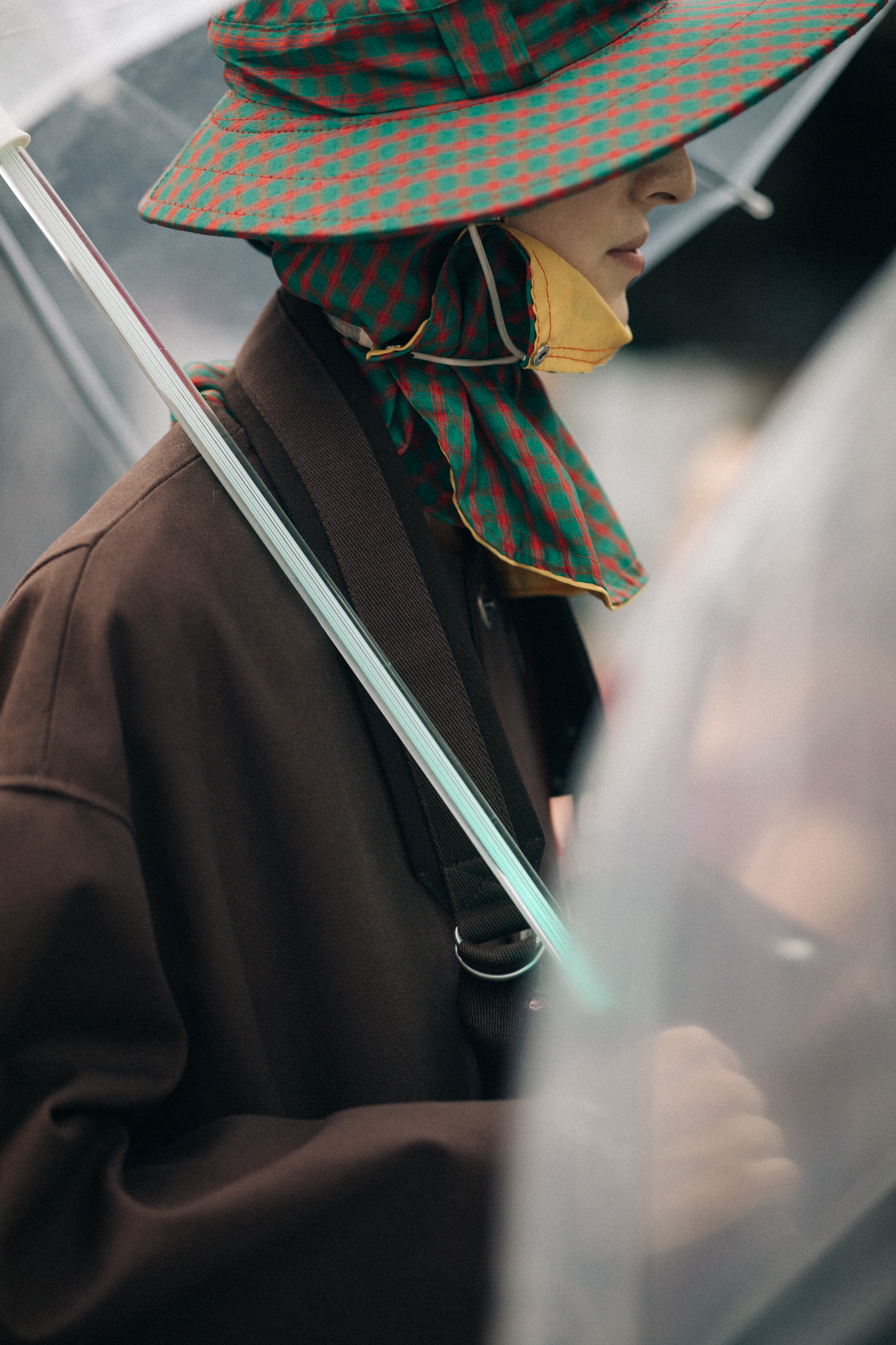 Male models wearing rain hats and umbrellas