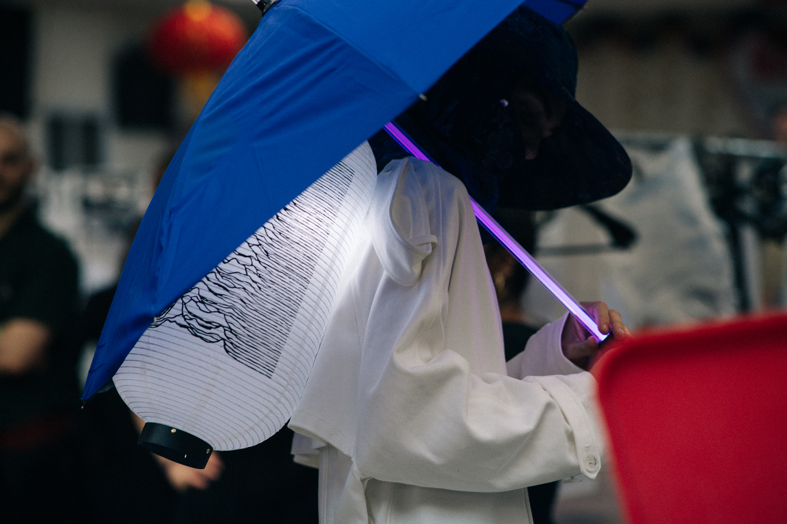 Male model with covered head wearing umbrella