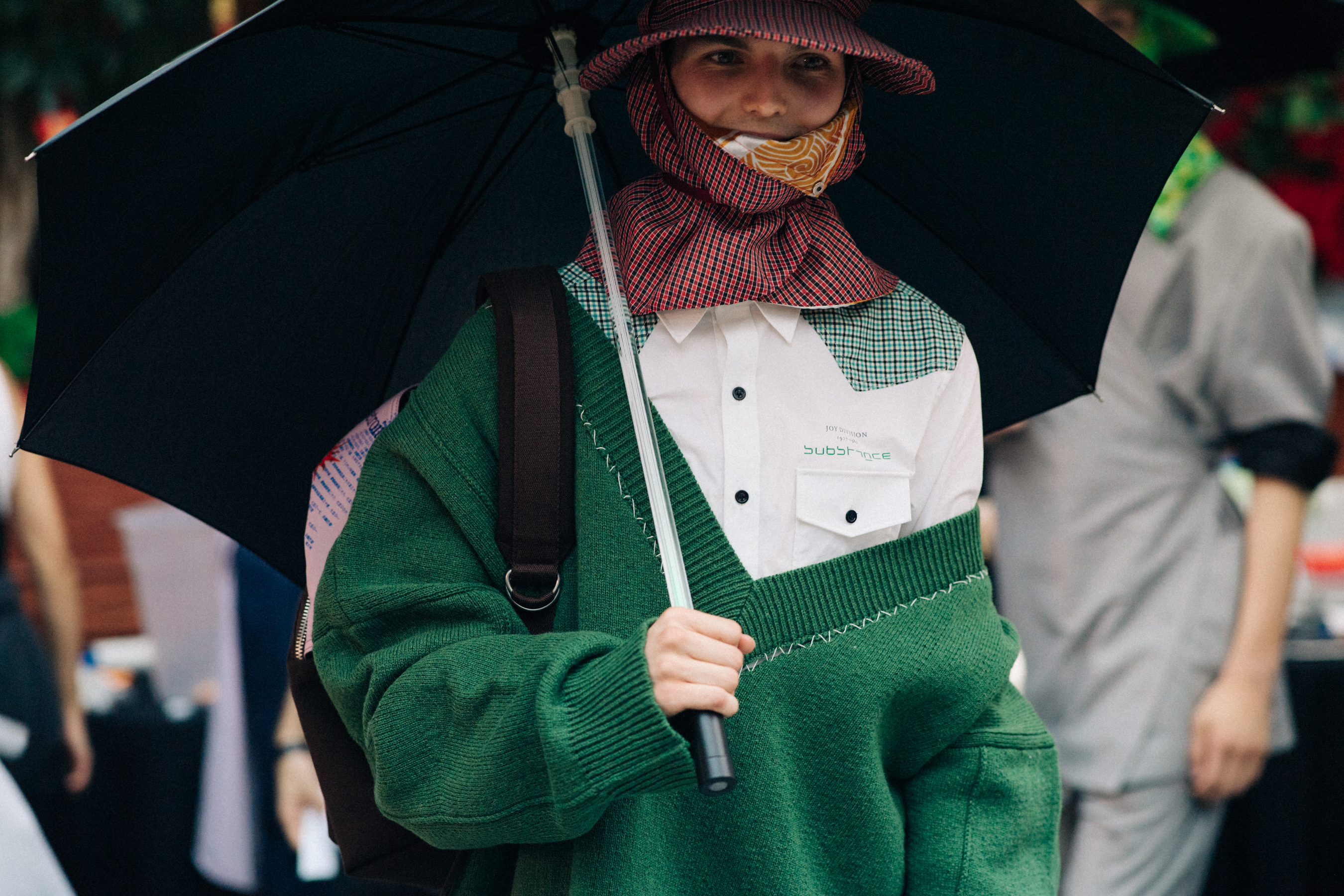 Male model with covered head wearing umbrella