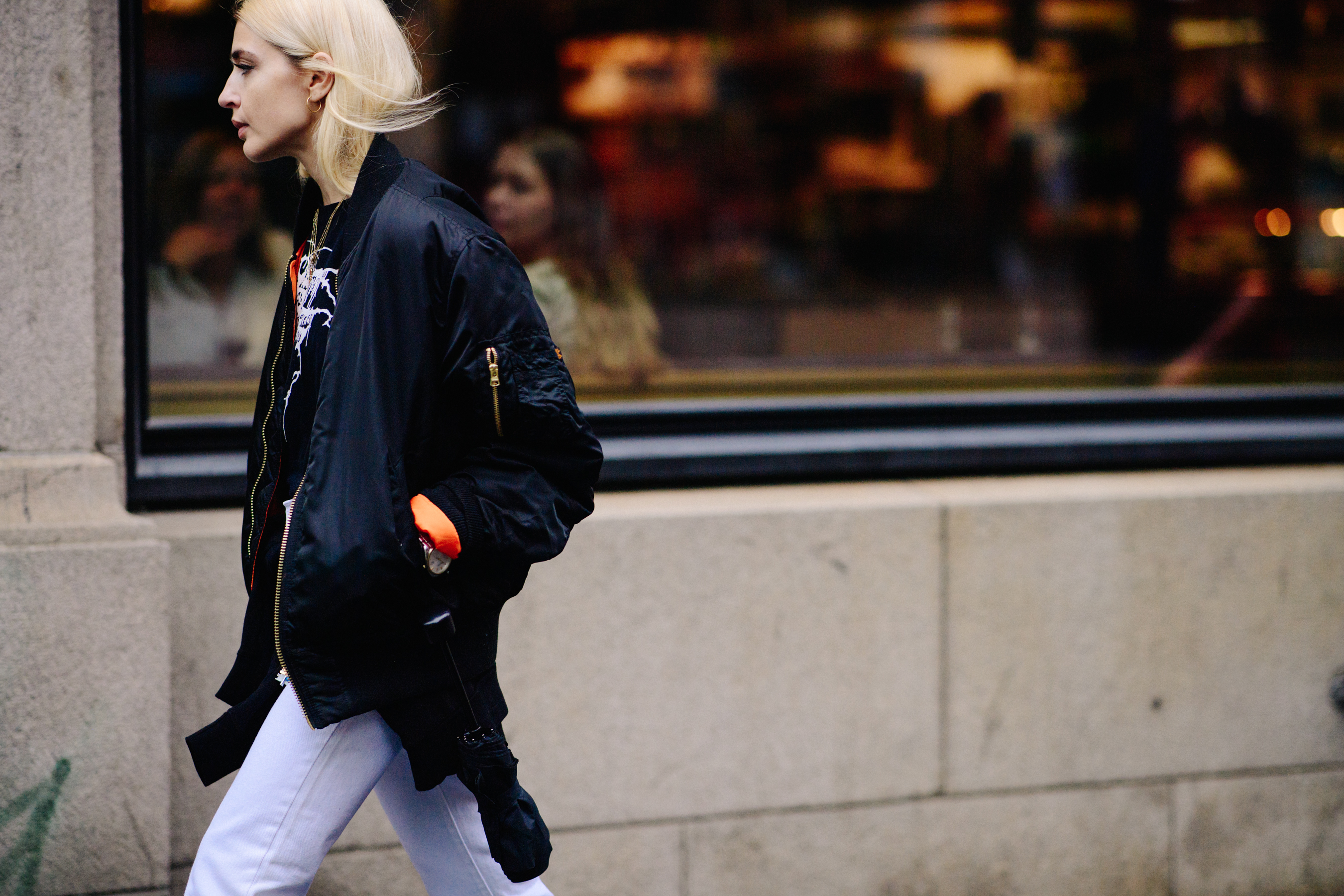 Woman wearing black bomber and jeans