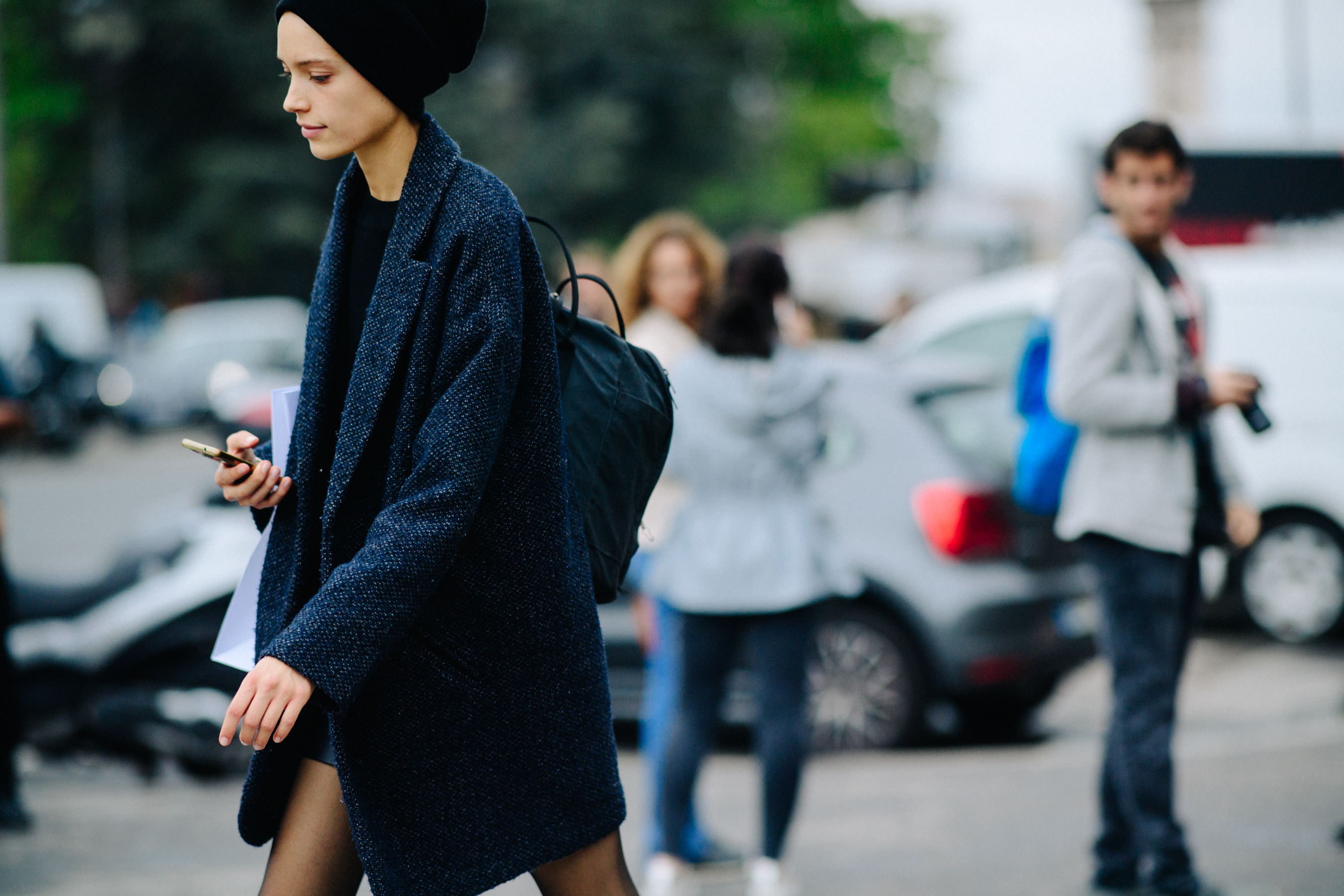 Model wearing hat and a coat after a show