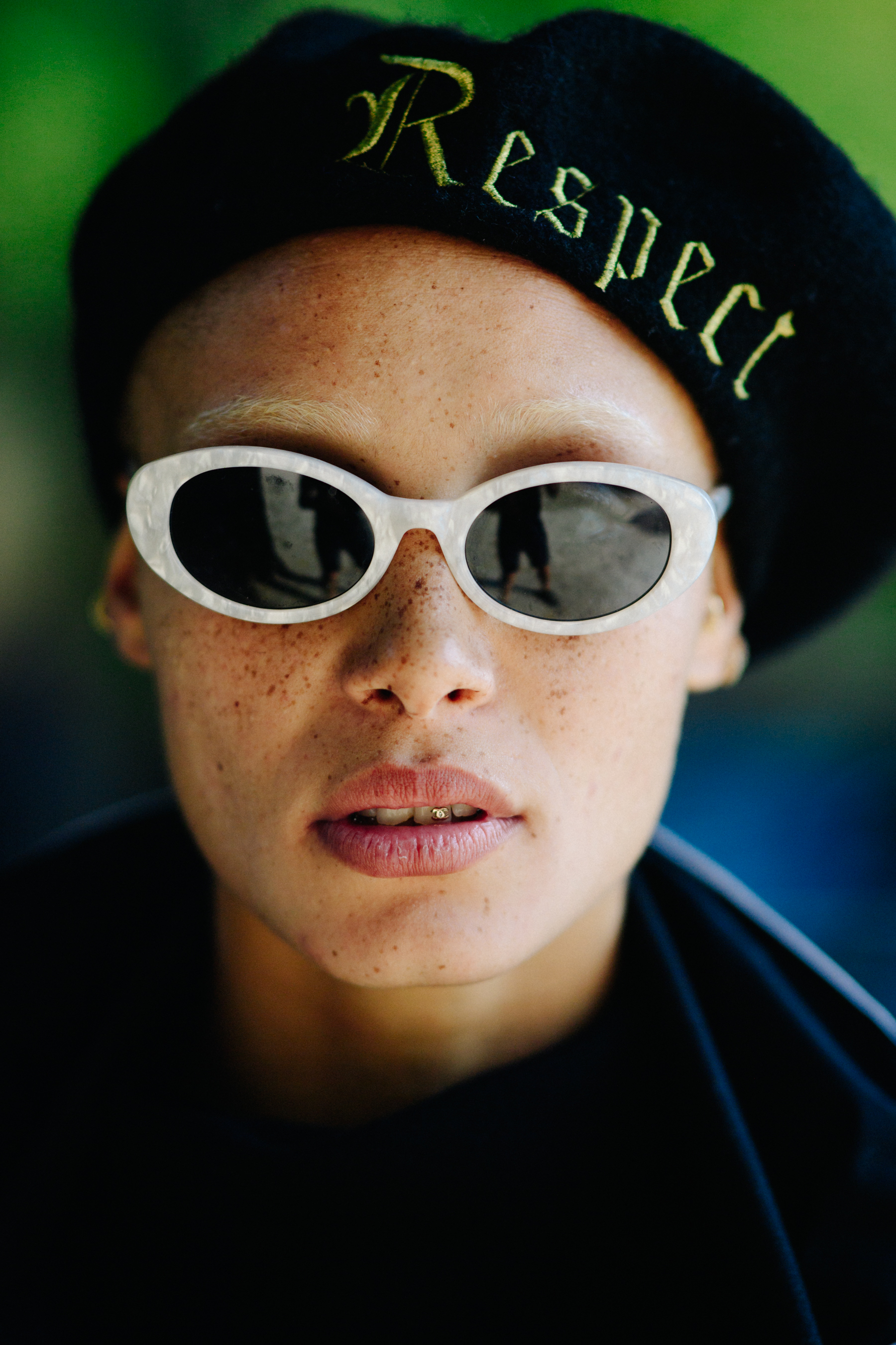 British model wearing white glasses and beret
