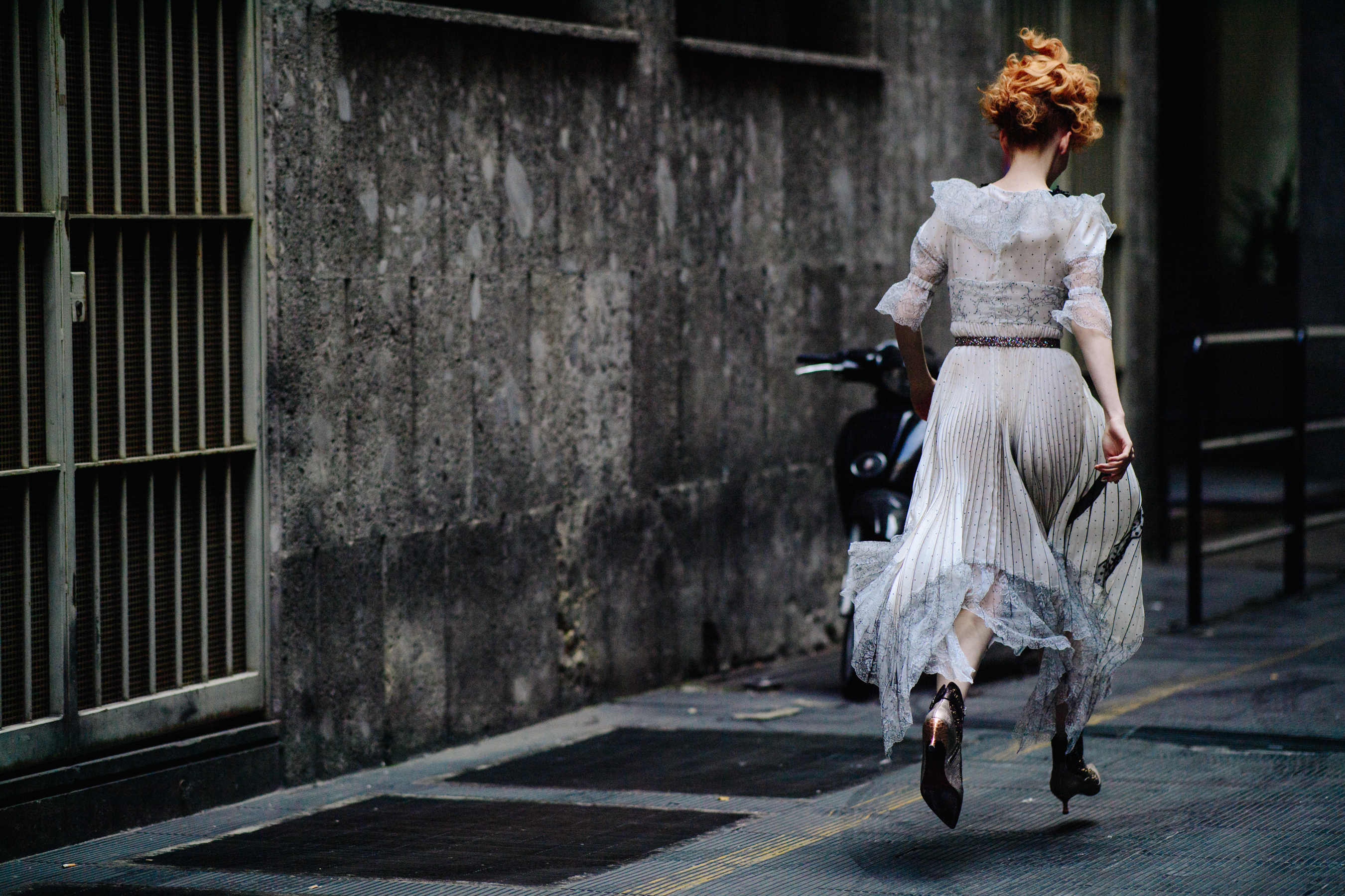 Back of woman running in white and black dress