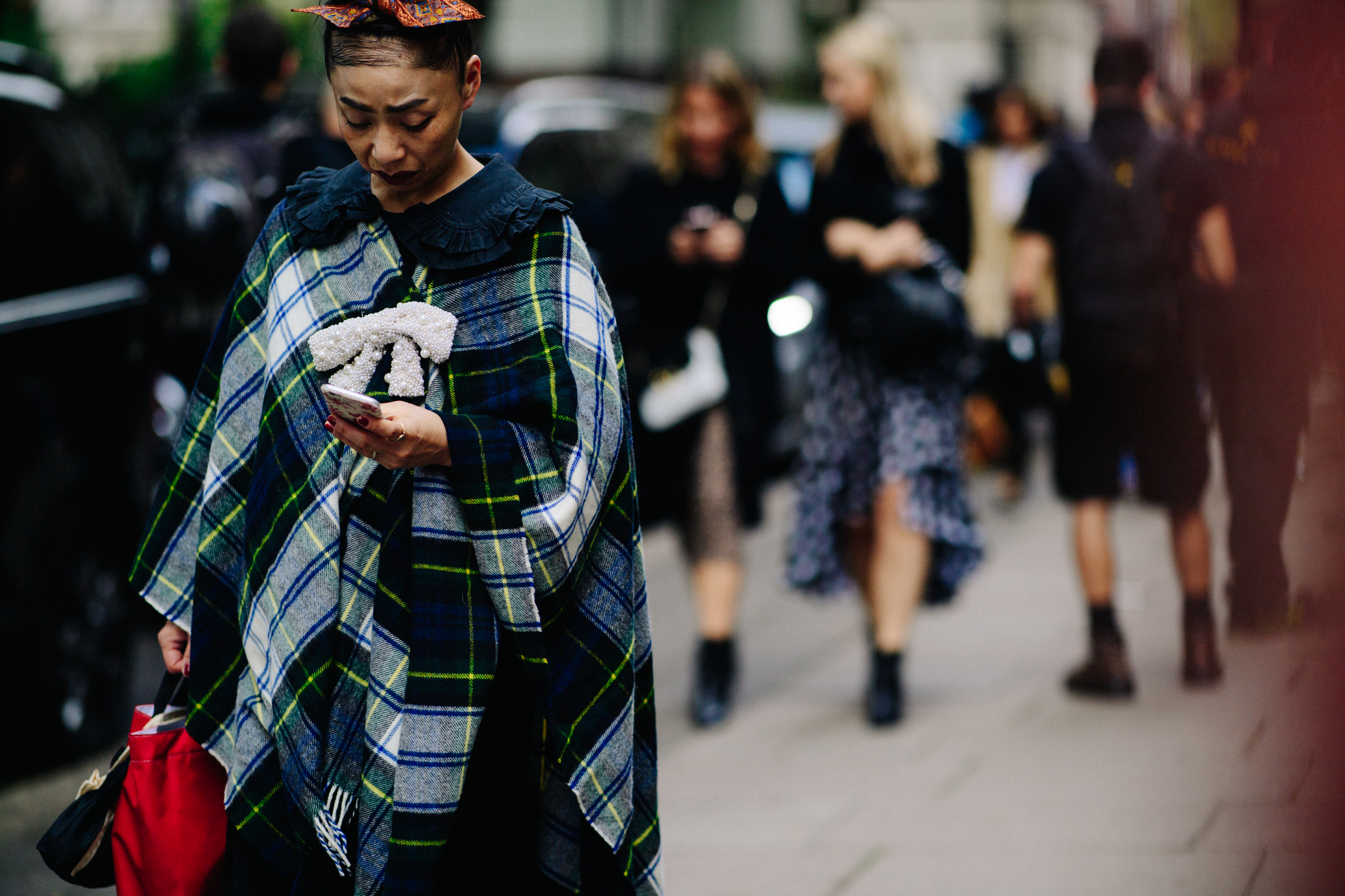 Woman wearing poncho with pearl broche