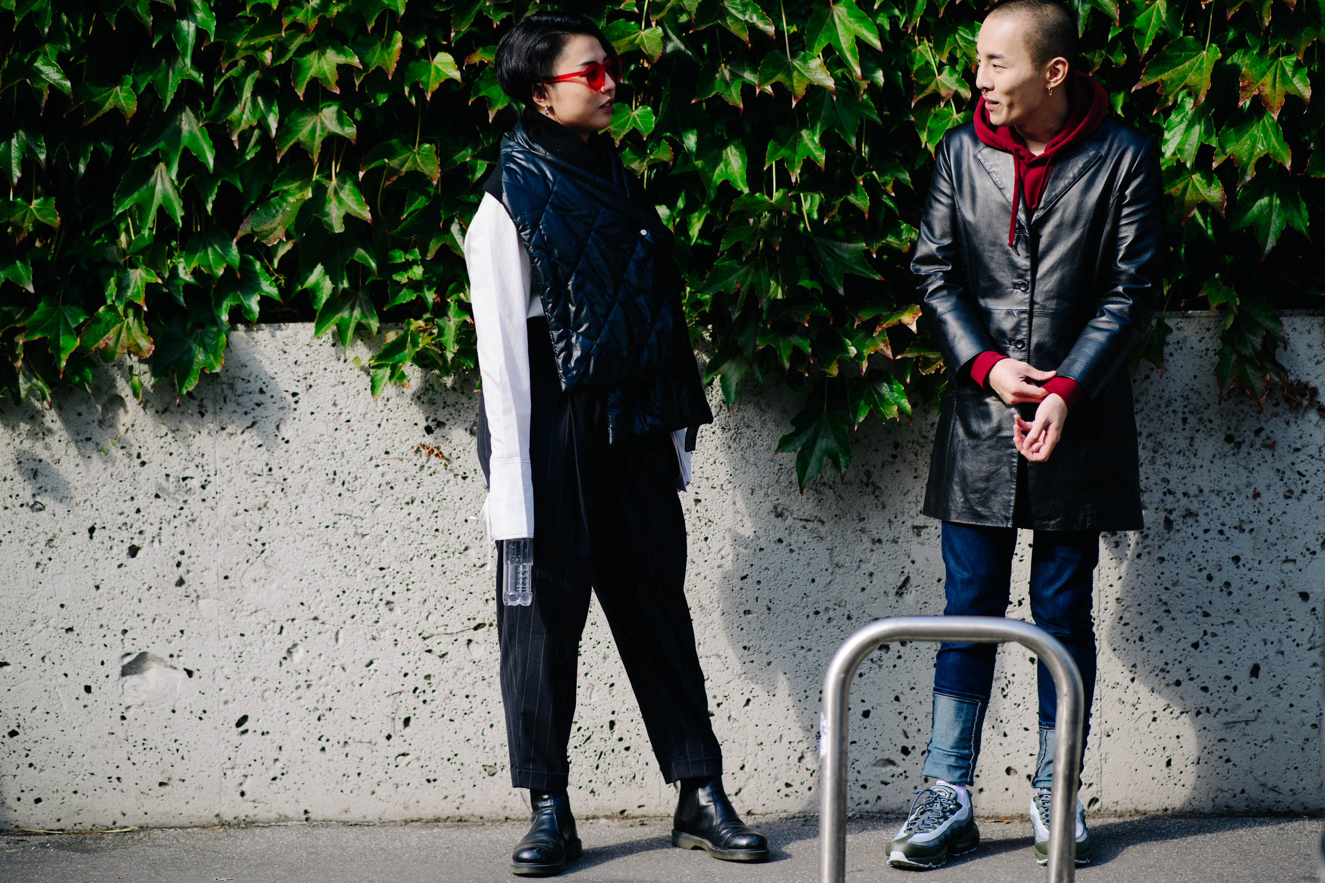Couple standing in sunlight wearing black leather