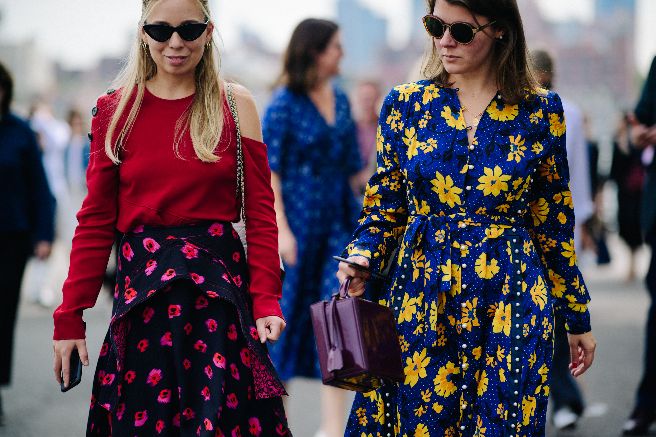 Two women wearing floral printed dresses