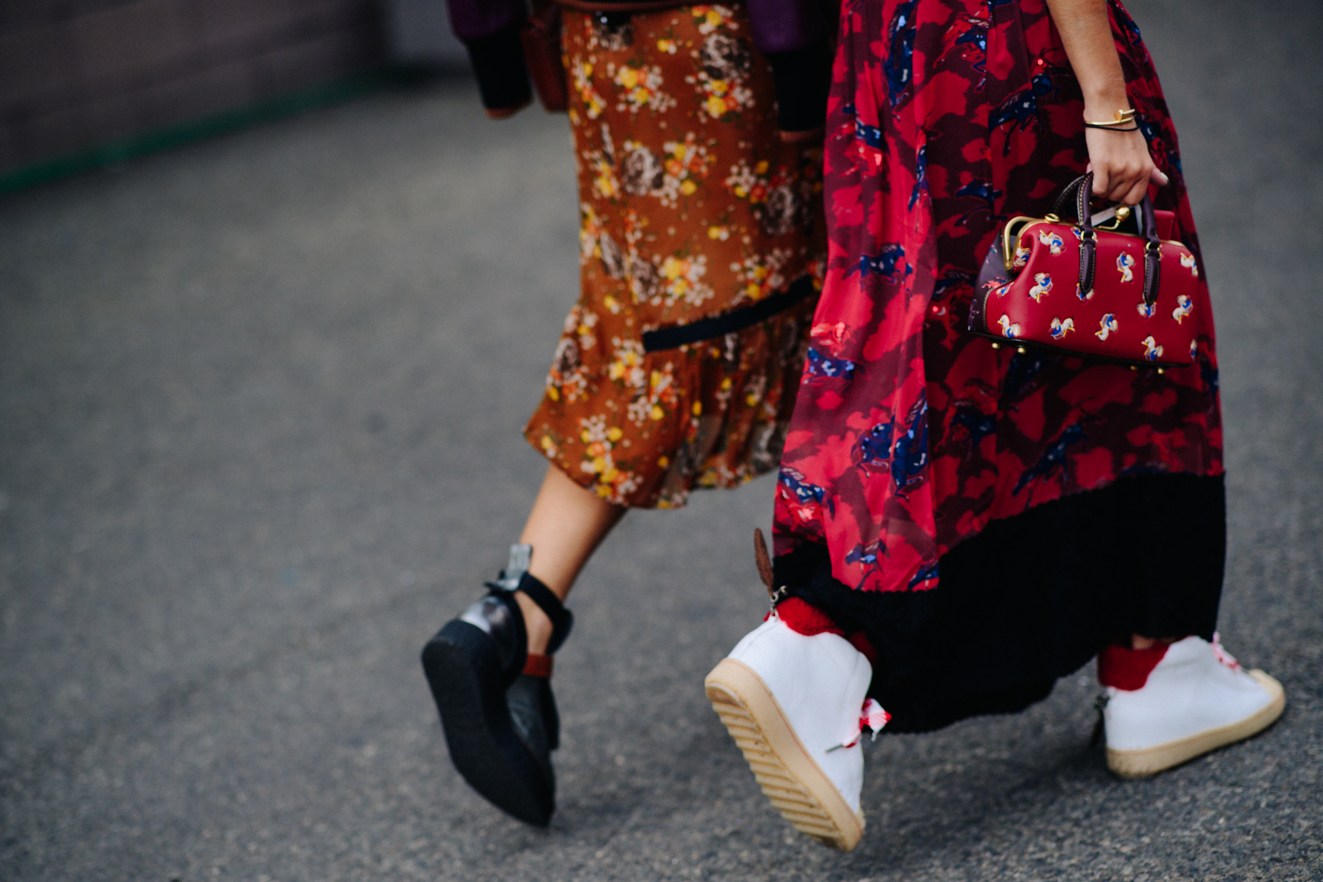 Two women wearing floral pattern dresses