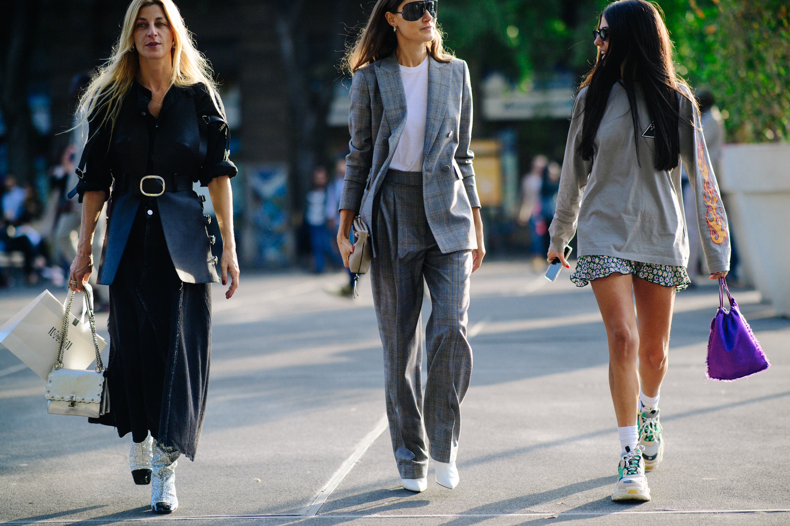 Three women walking in dark outfits