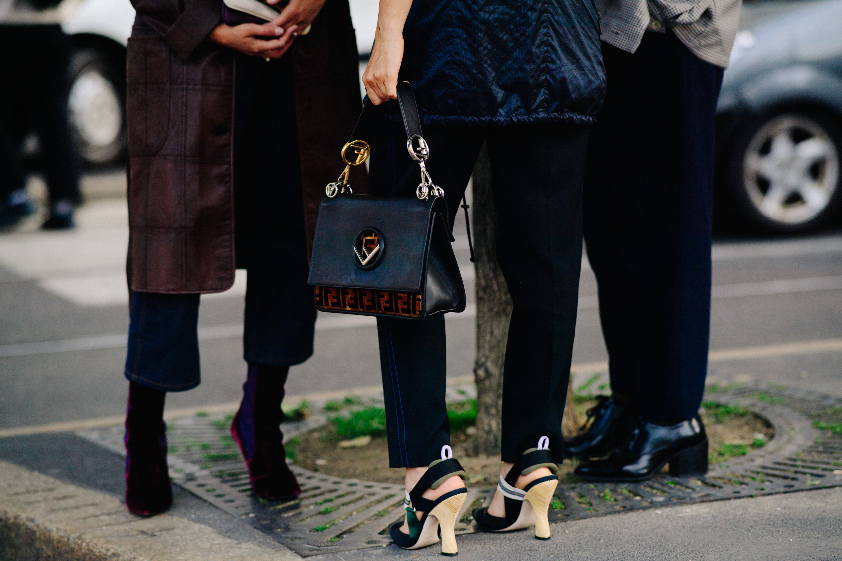 Closeup of a group of peoples feet in black trousers