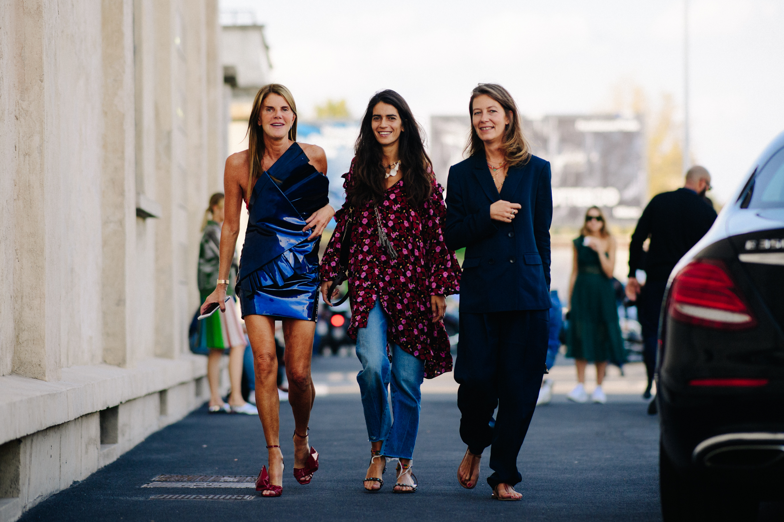 Three women walking wearing dark colours and open toe shoes