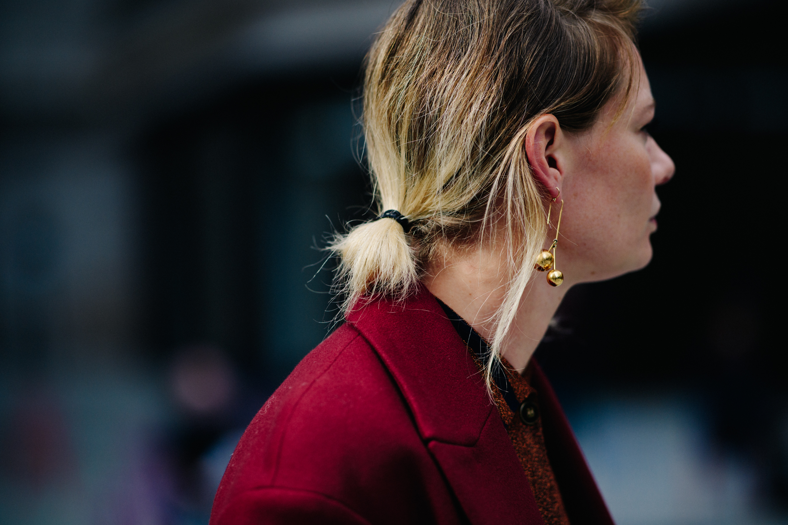 Woman wearing golden cherry shaped earring