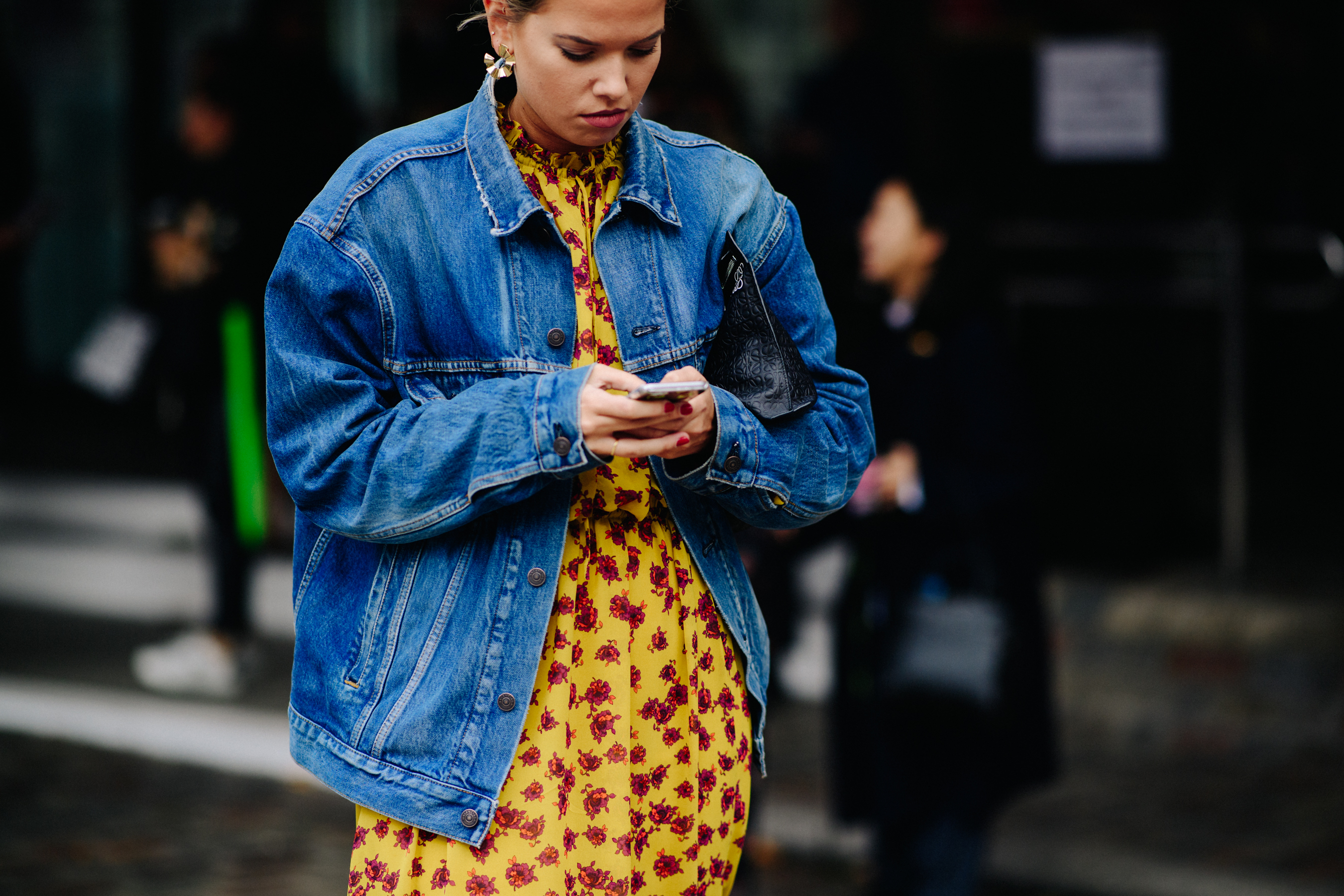 Woman wearing denim jacket over dress