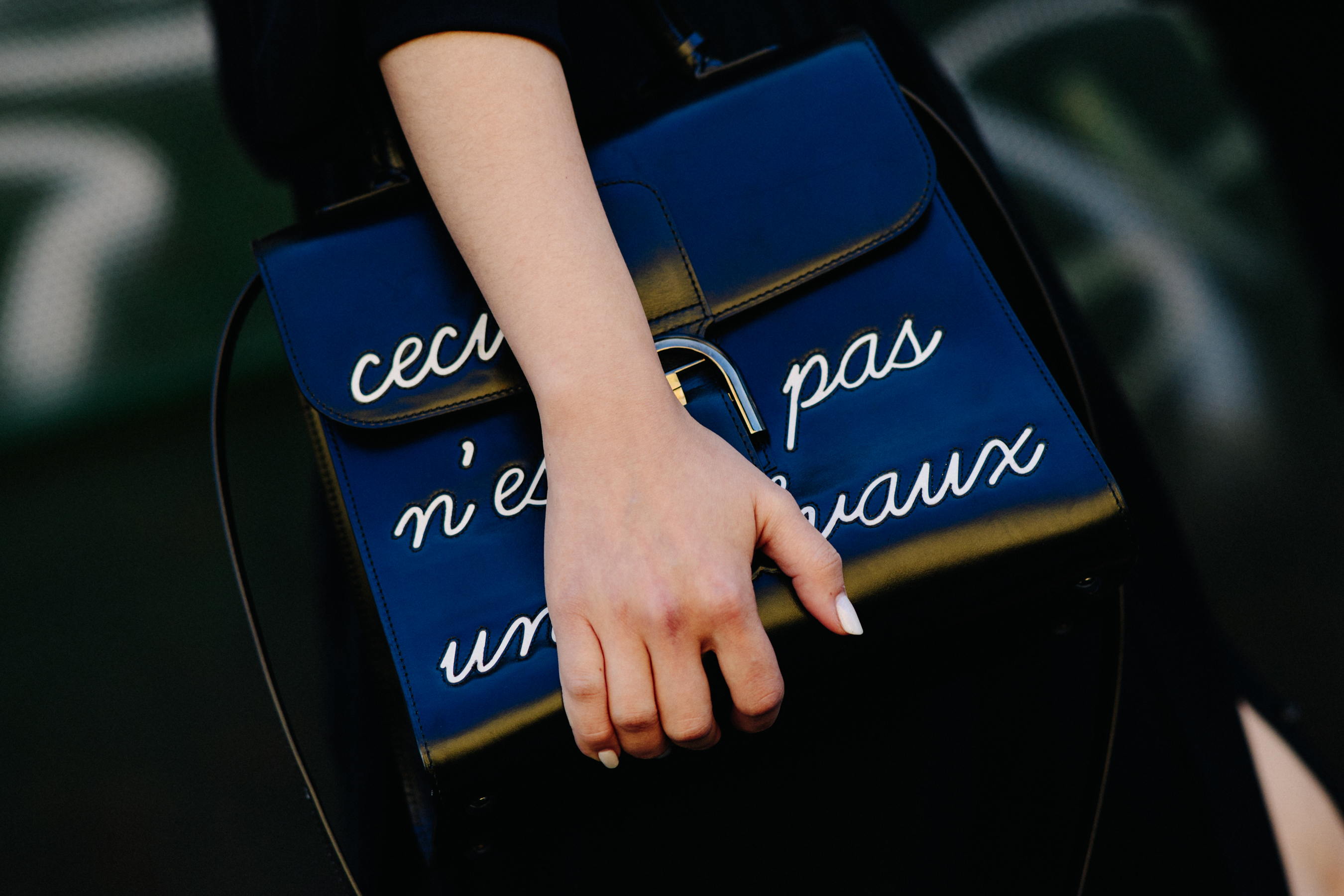 Closeup of woman holding black leather text bag