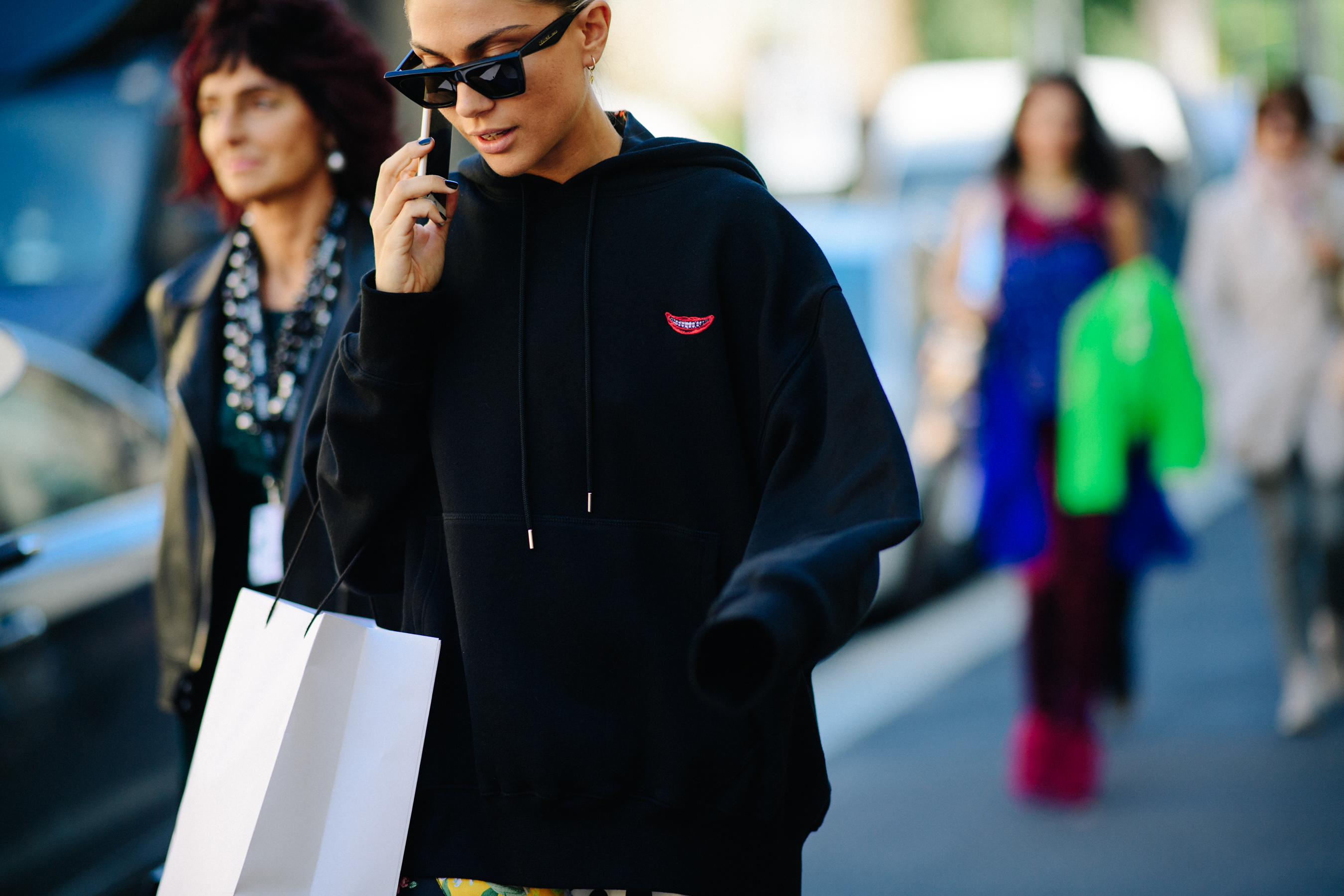 Woman talking on phone wearing black hoodie