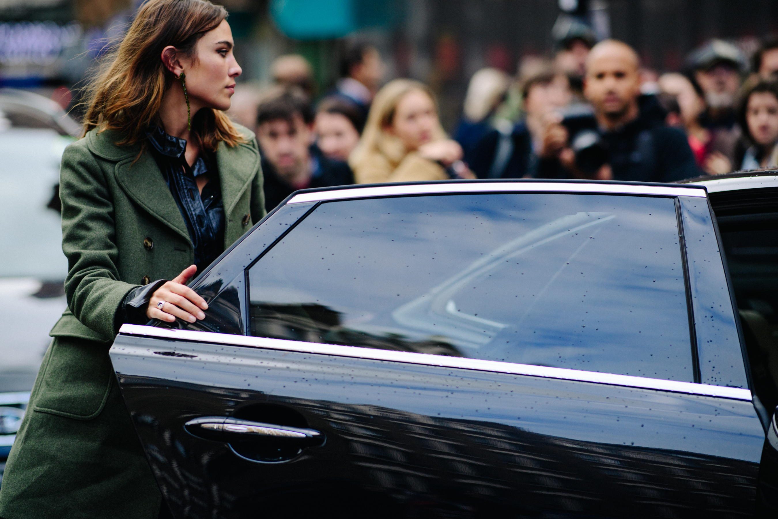 British model and designer wearing green coat