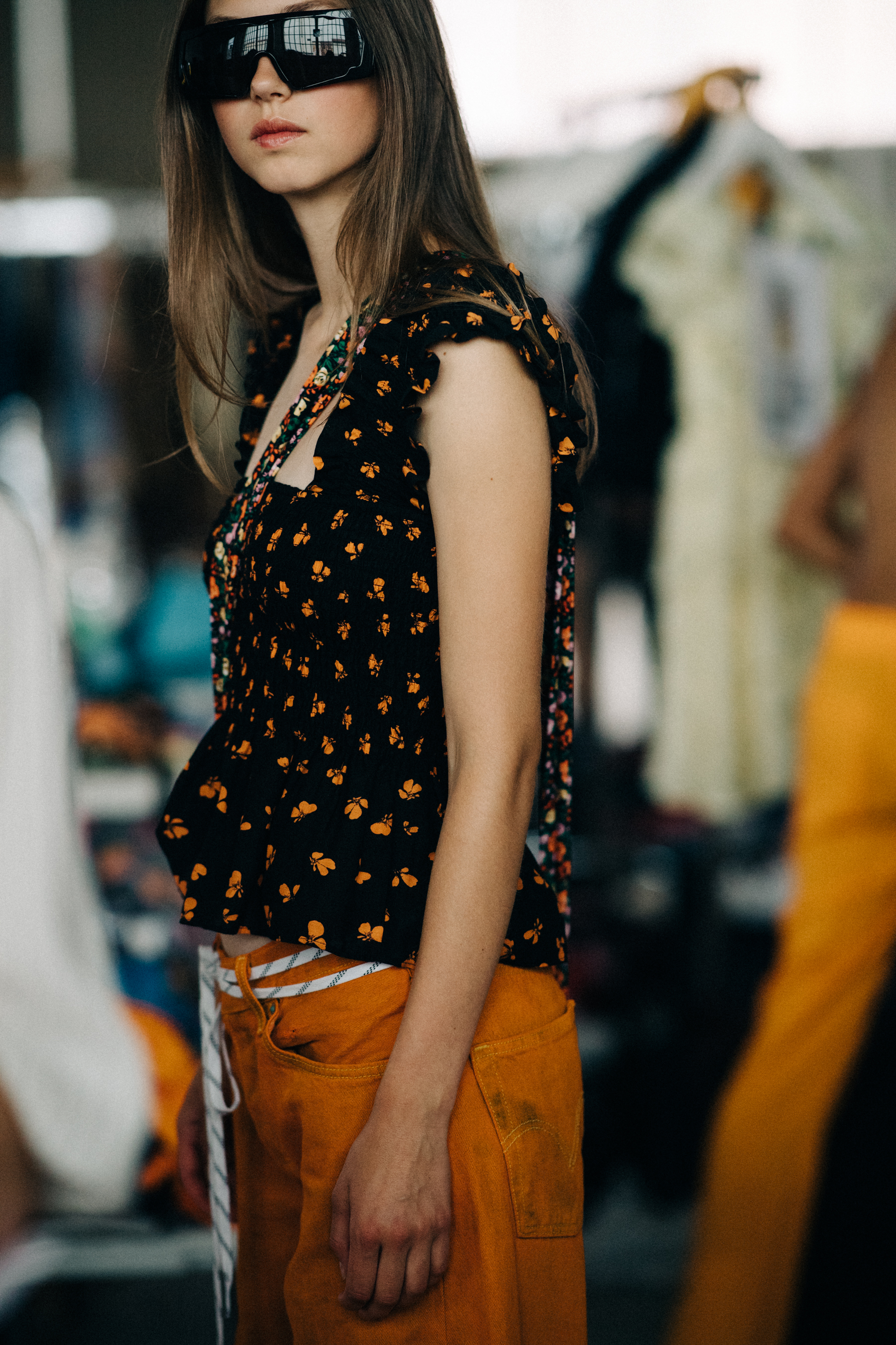 Model wearing floral top before a show