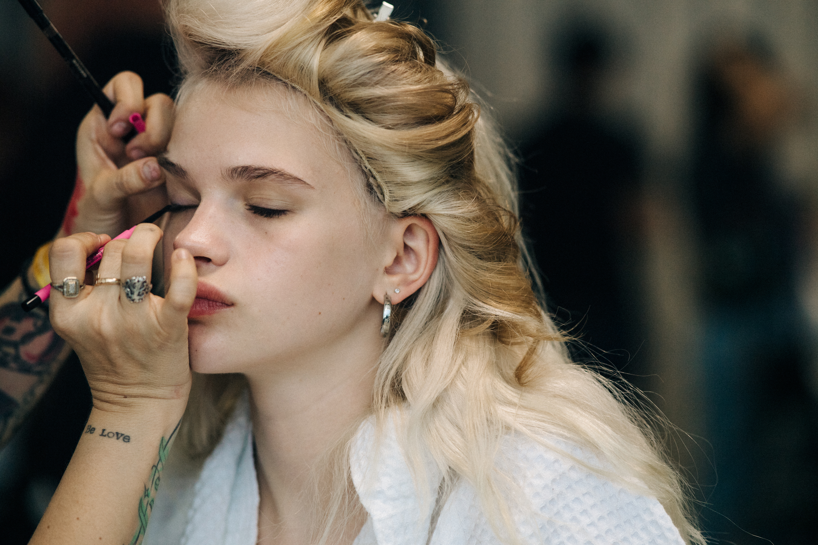 Blonde model having eye makeup applied