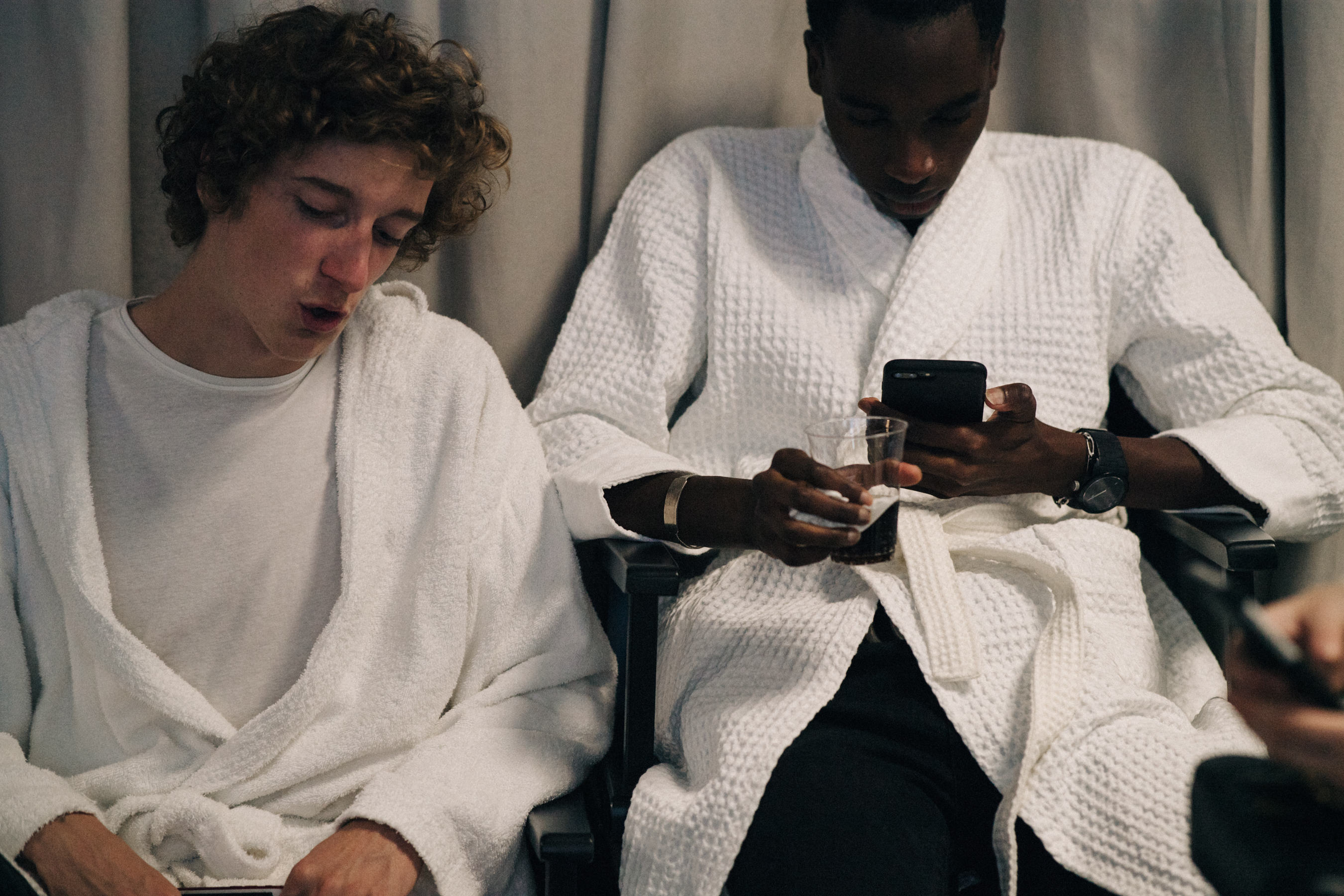 Two models waiitng backstage in dressing robes