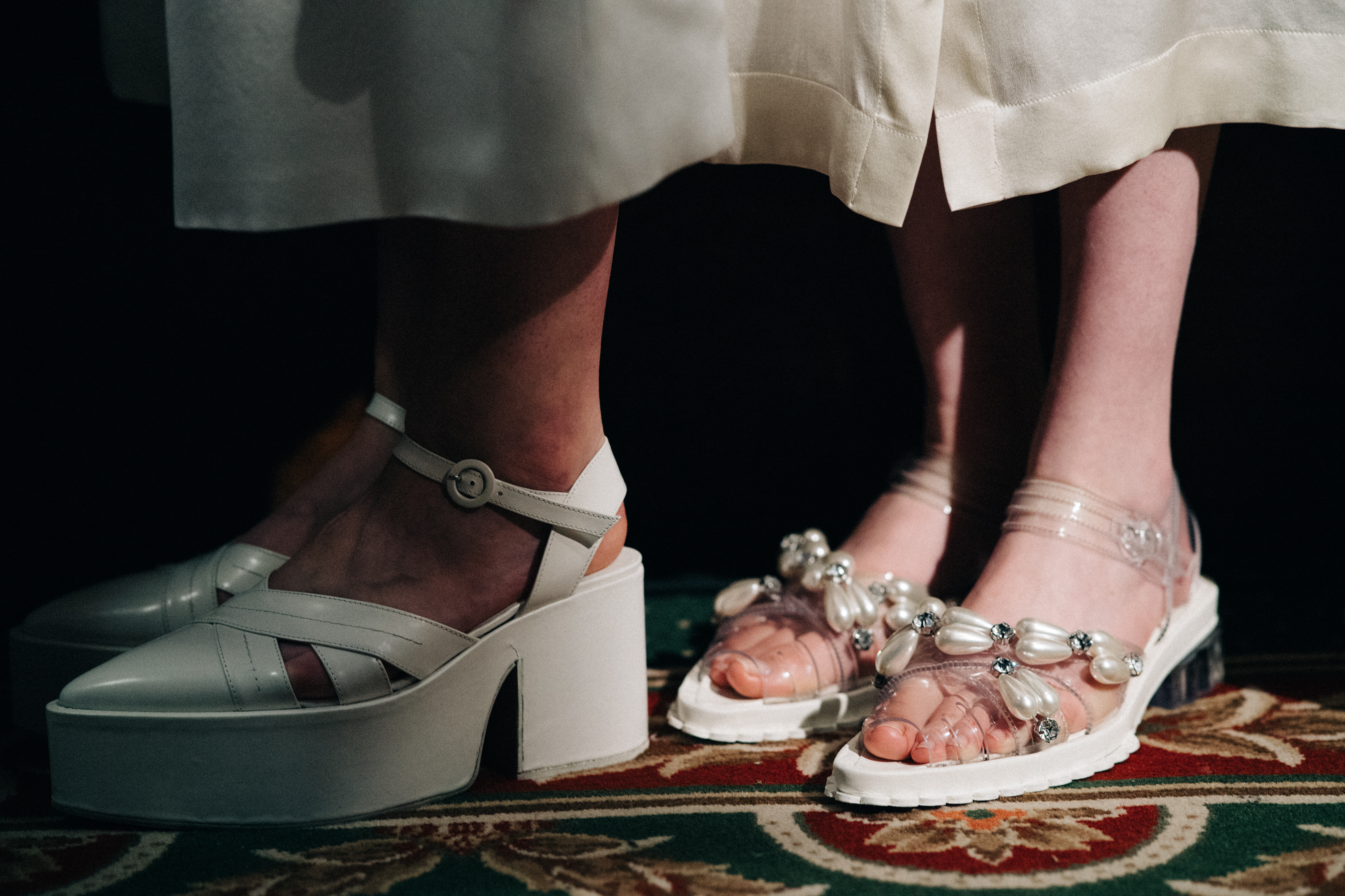 Models wearing white decorated shoes