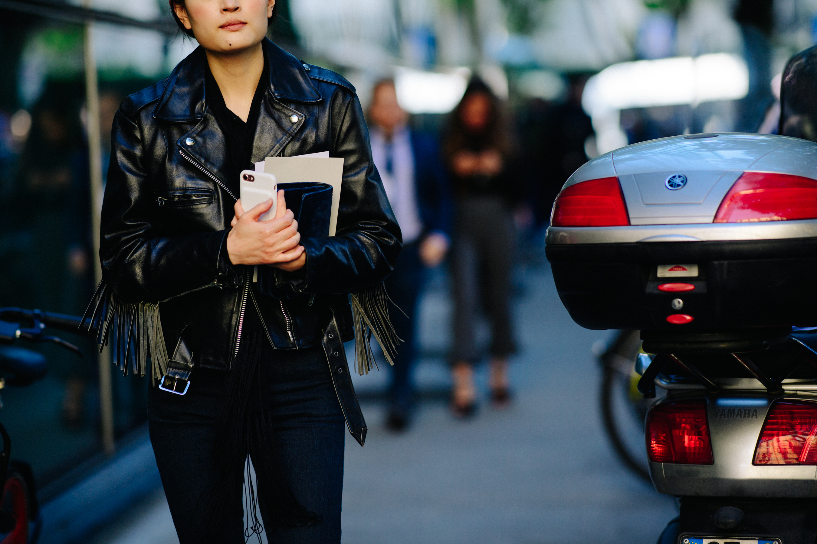 Woman in black leather jacket holding invite