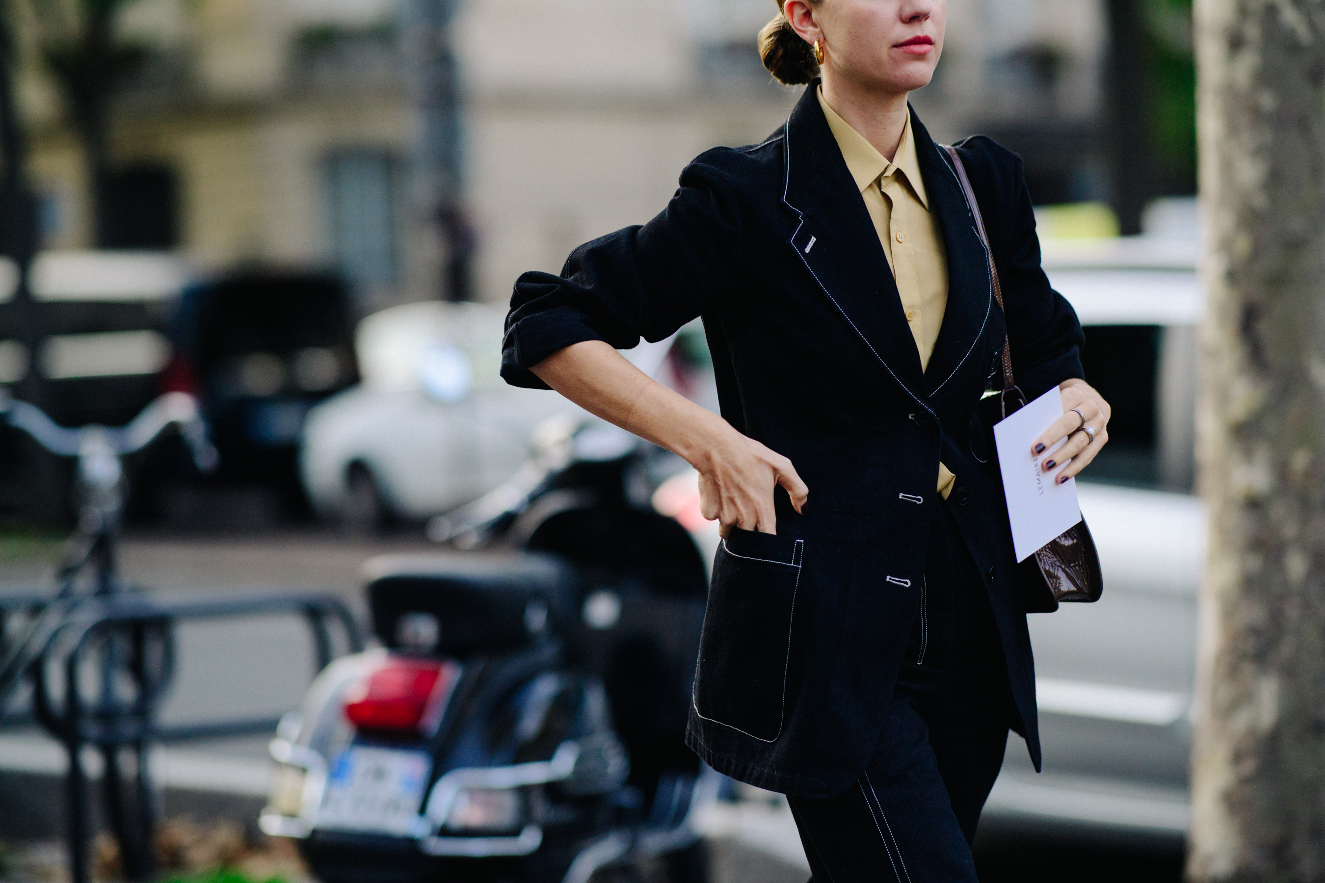 Woman wearing black suit with white stitching