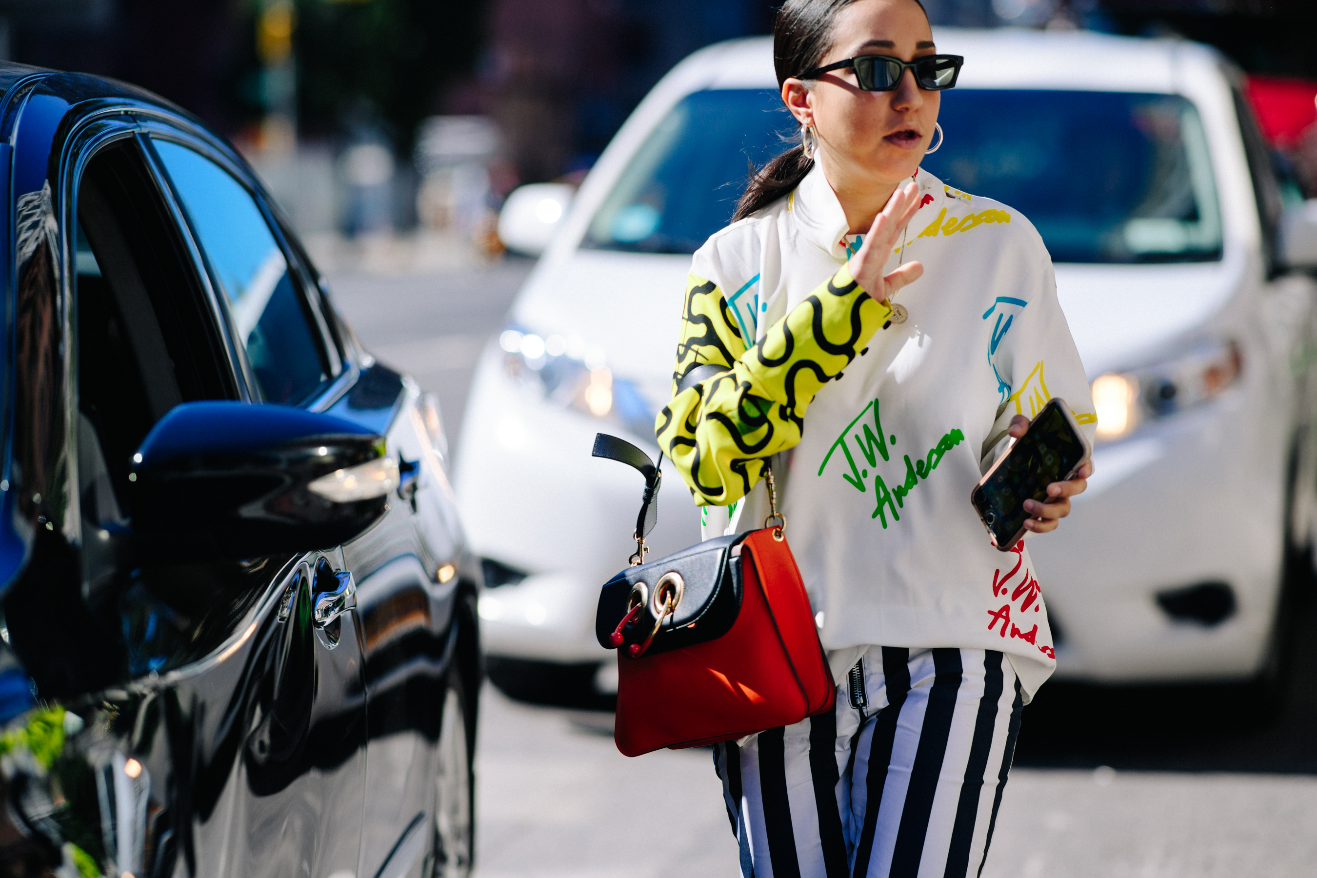 Woman wearing red J.W.Anderson piercing bag
