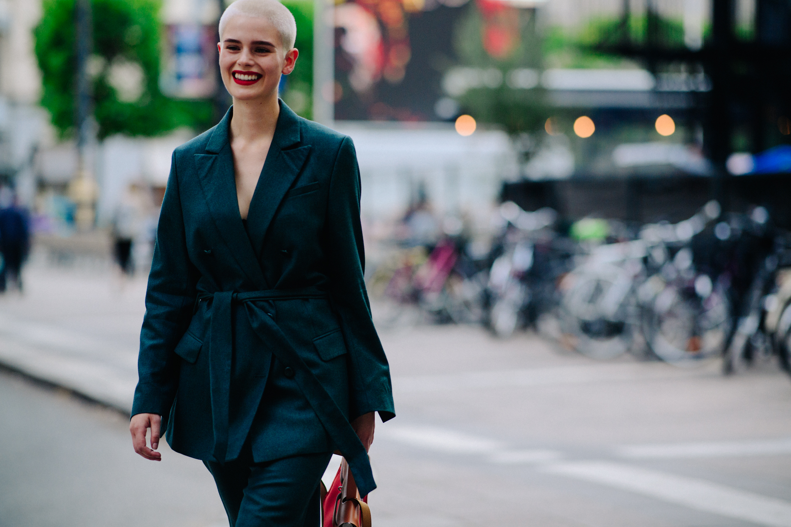 Model with shaved head wearing green suit