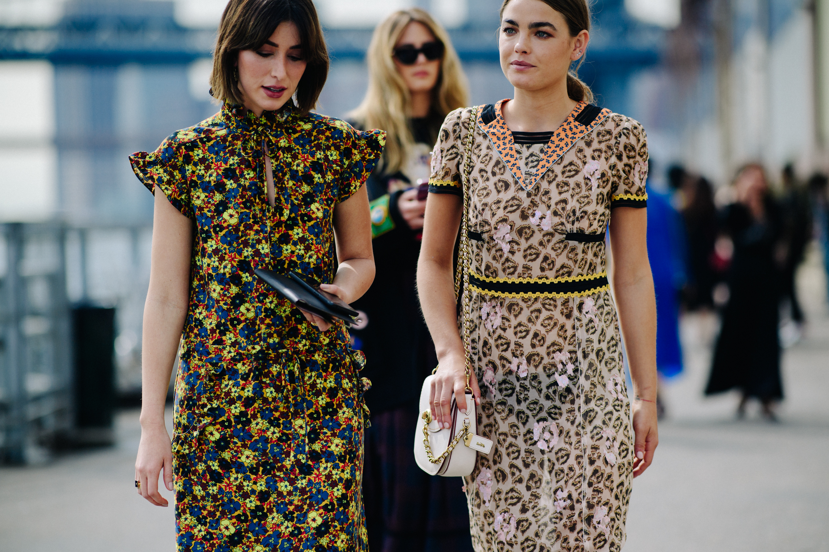 Two women wearing printed dresses