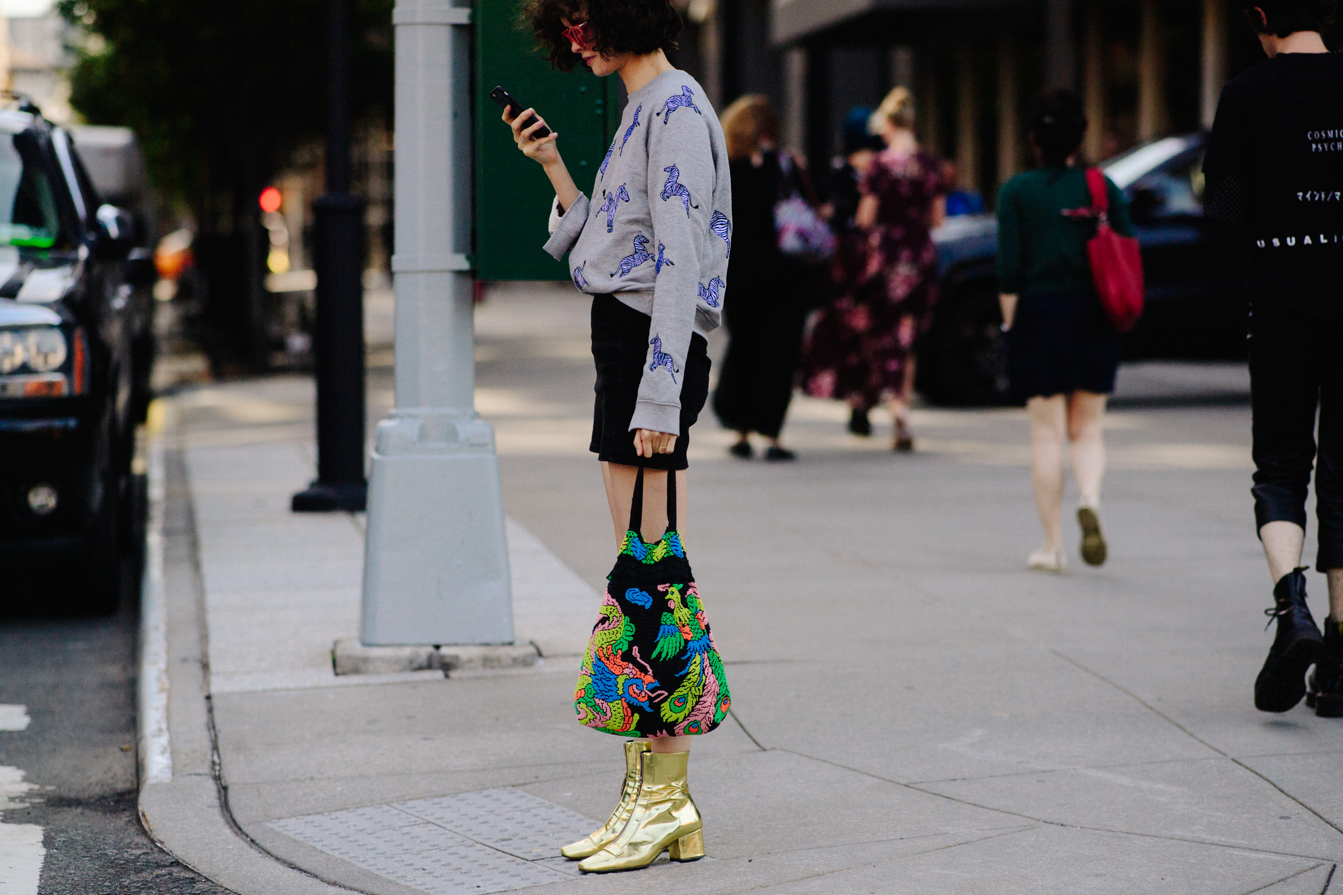 Woman wearing golden boots and green bag