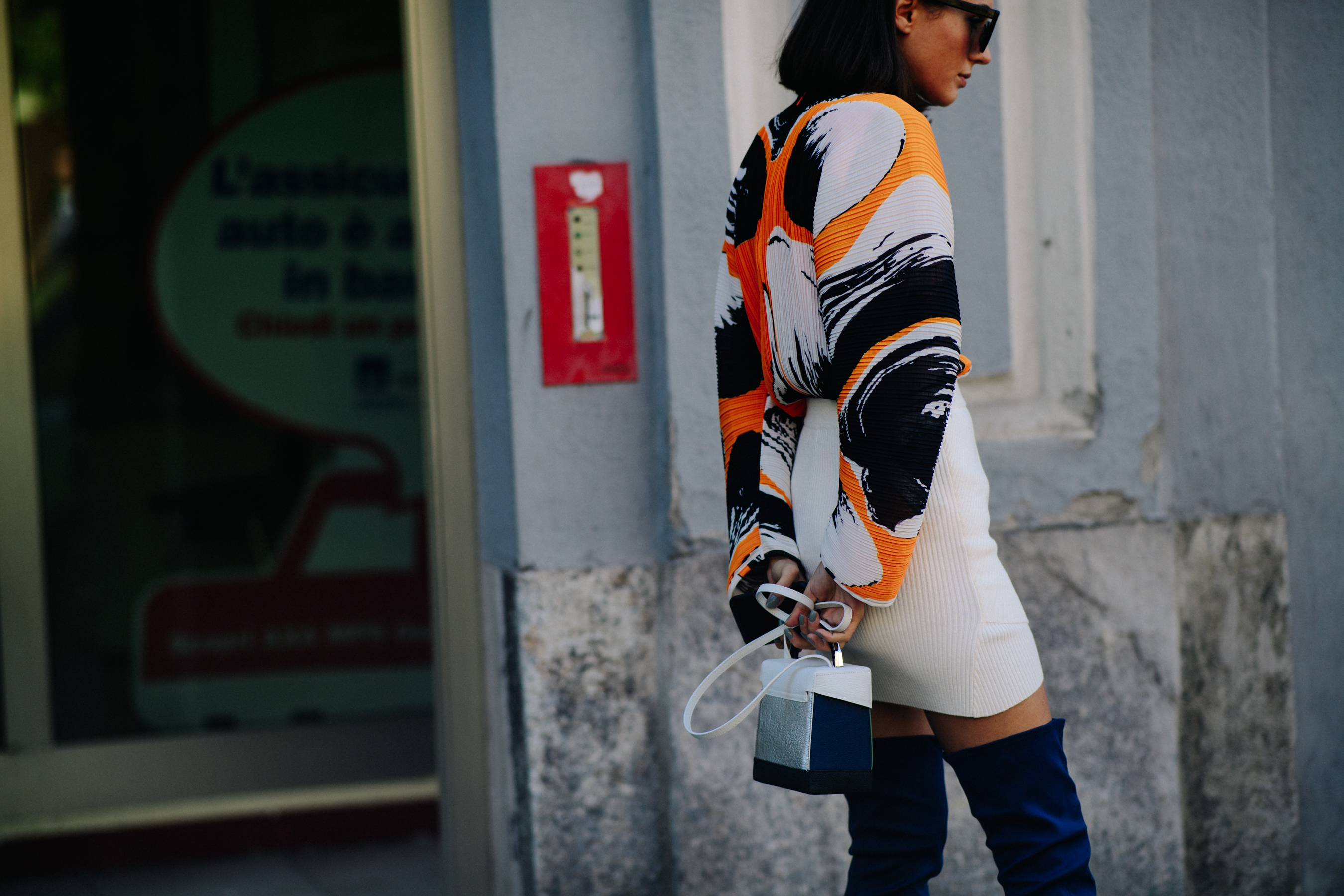 Woman holding white hangbag behind her back