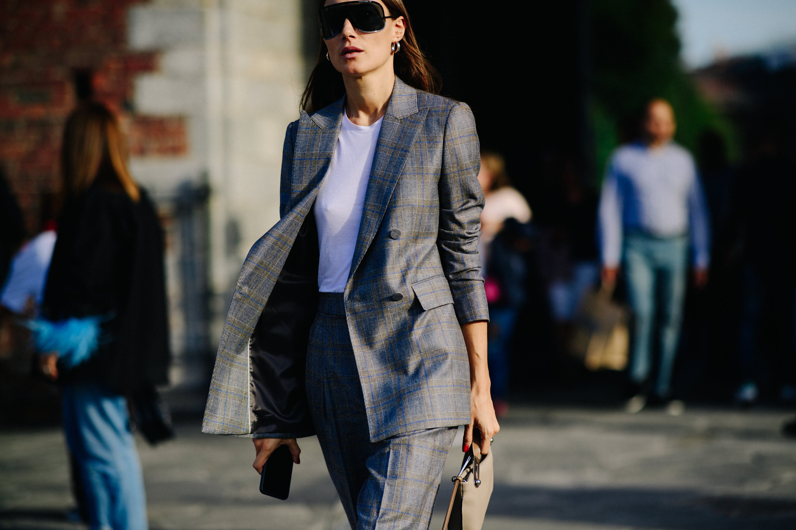 Woman walking in grey check suit jacket and trousers
