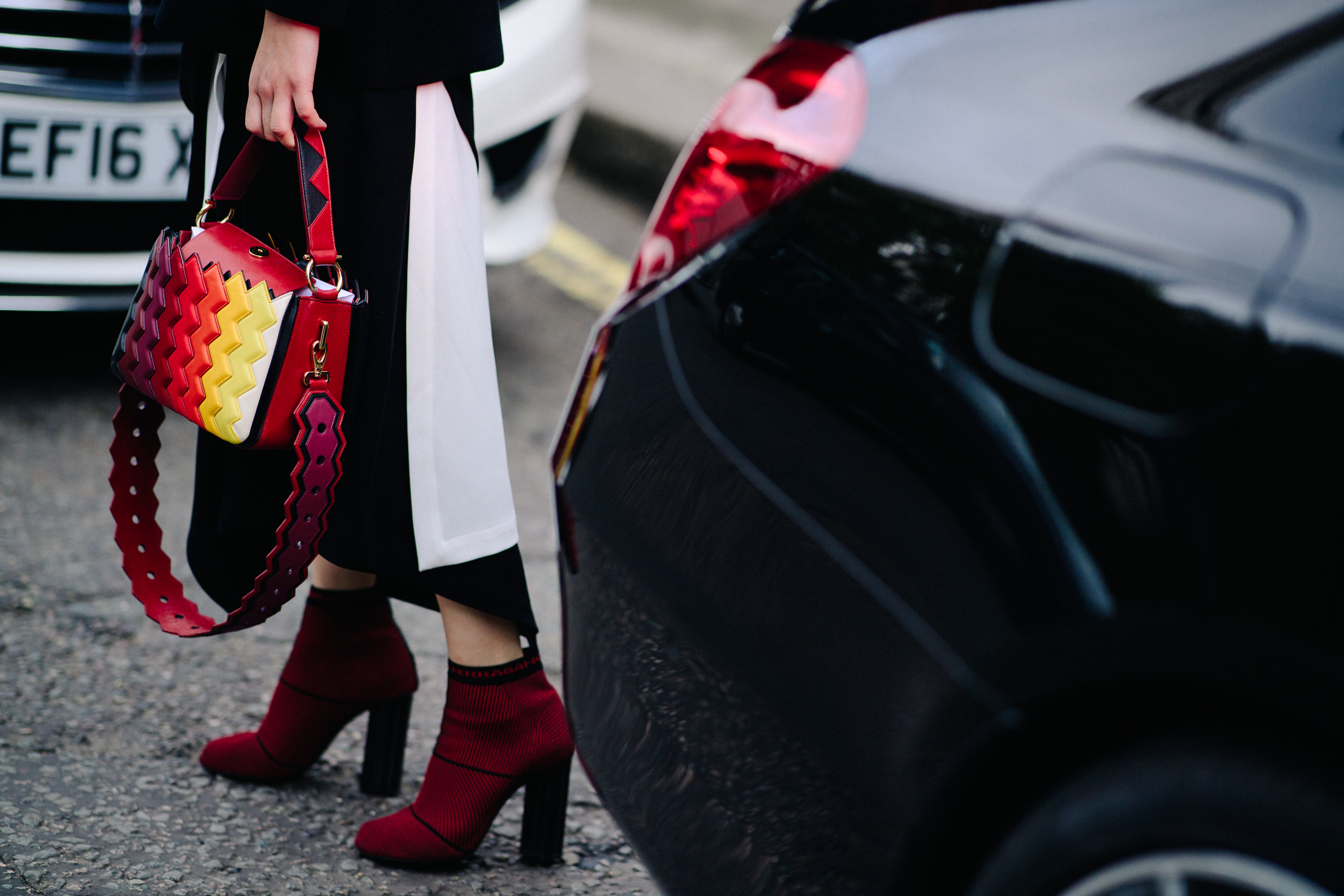 Woman wearing red ankle boots and a bag