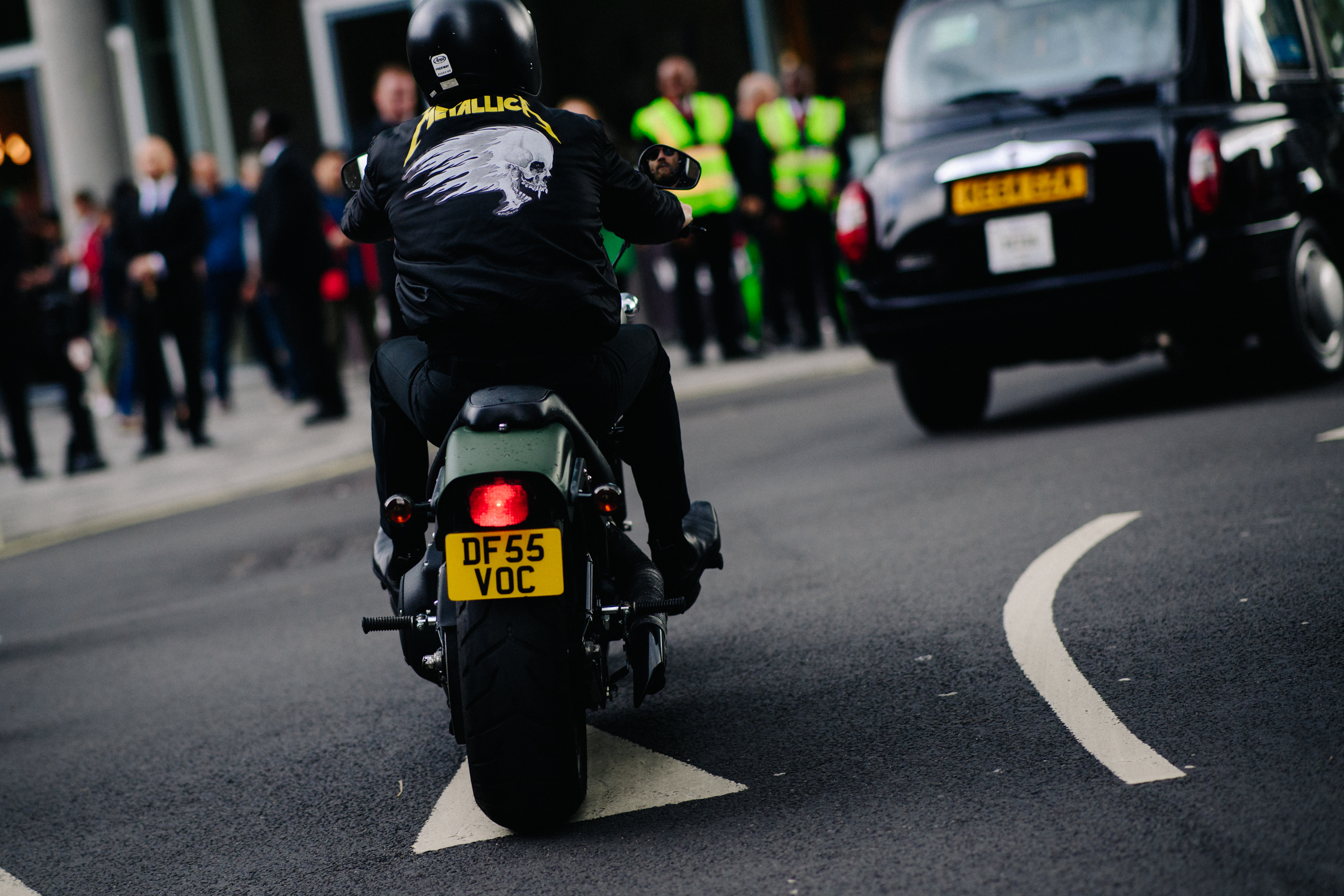 Style consultant wearing Metallica bomber on a bike