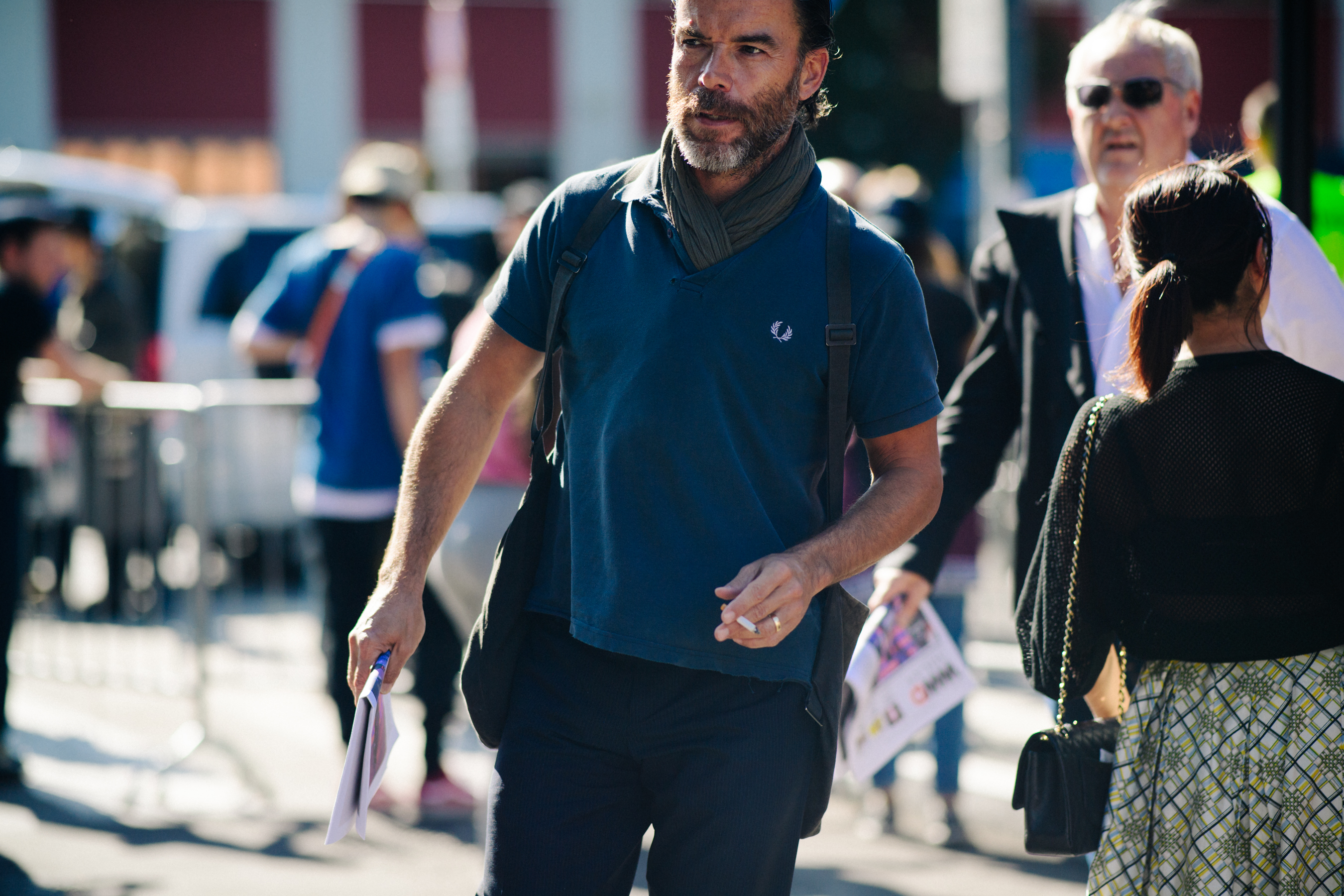 Man wearing blue polo shirt with scarf tucked in