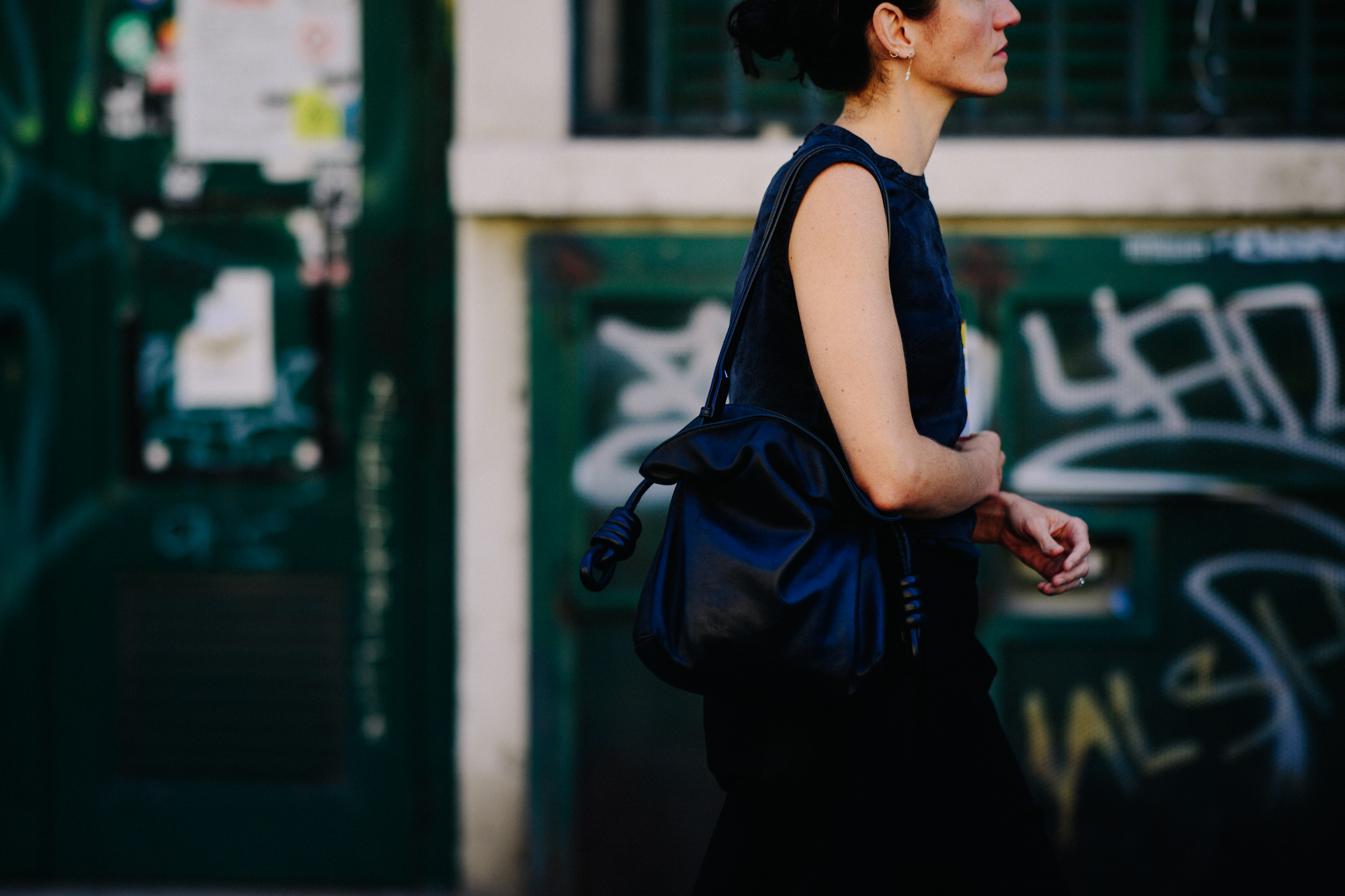 Woman wearing dark outfit with black bag