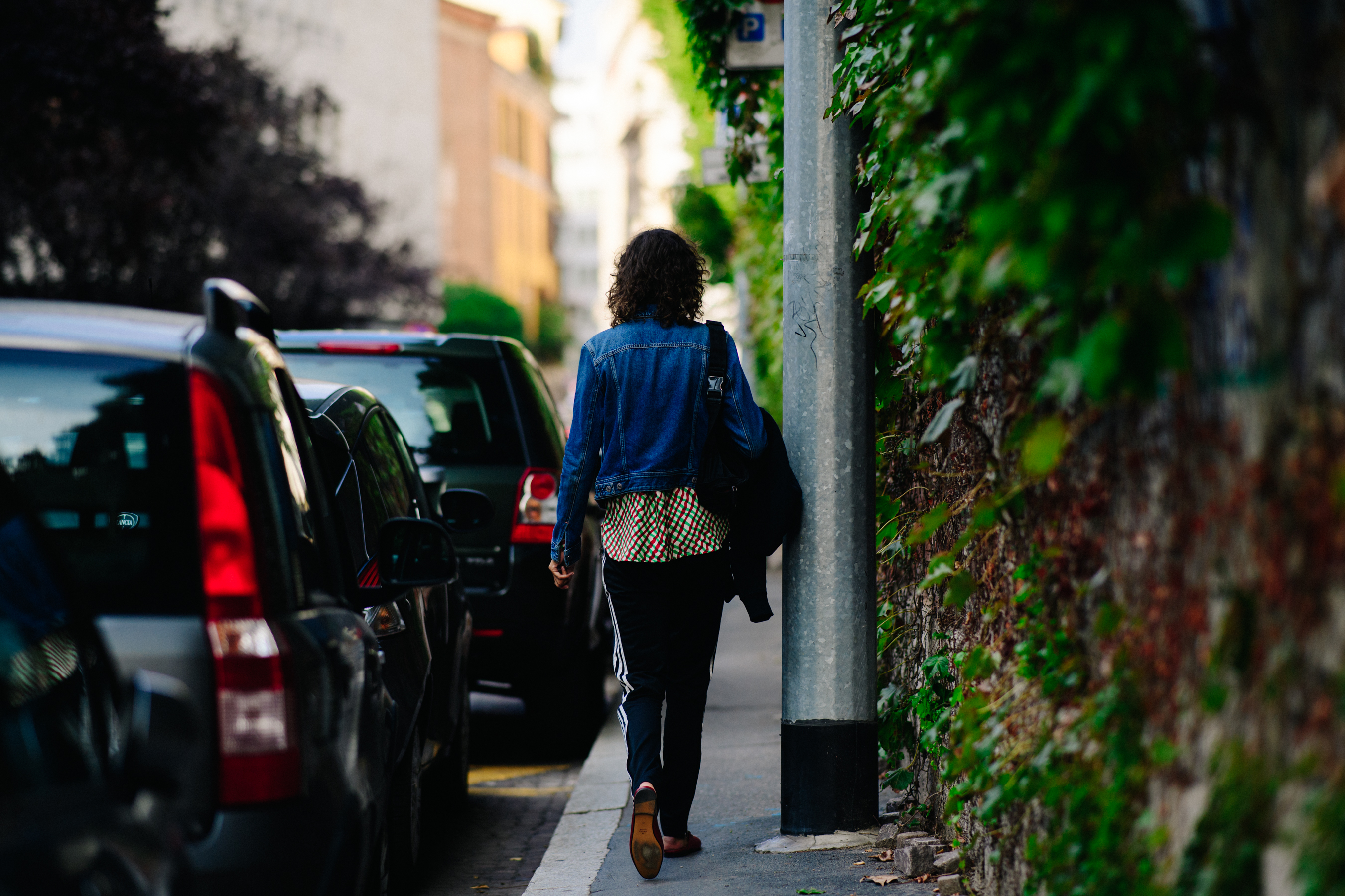 American model walking away wearing denim jacket