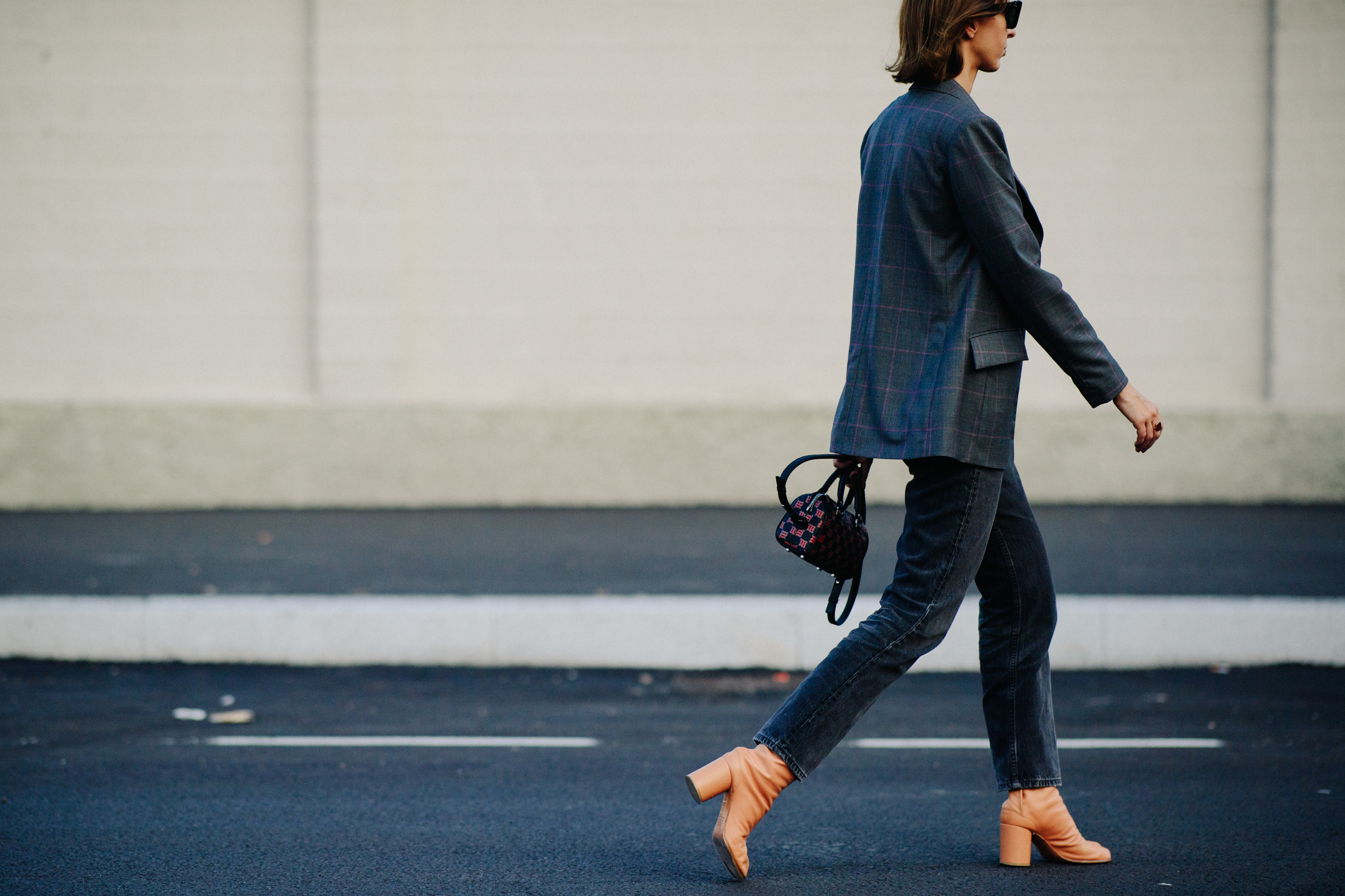 Side of woman walking in brown leather heeled boots
