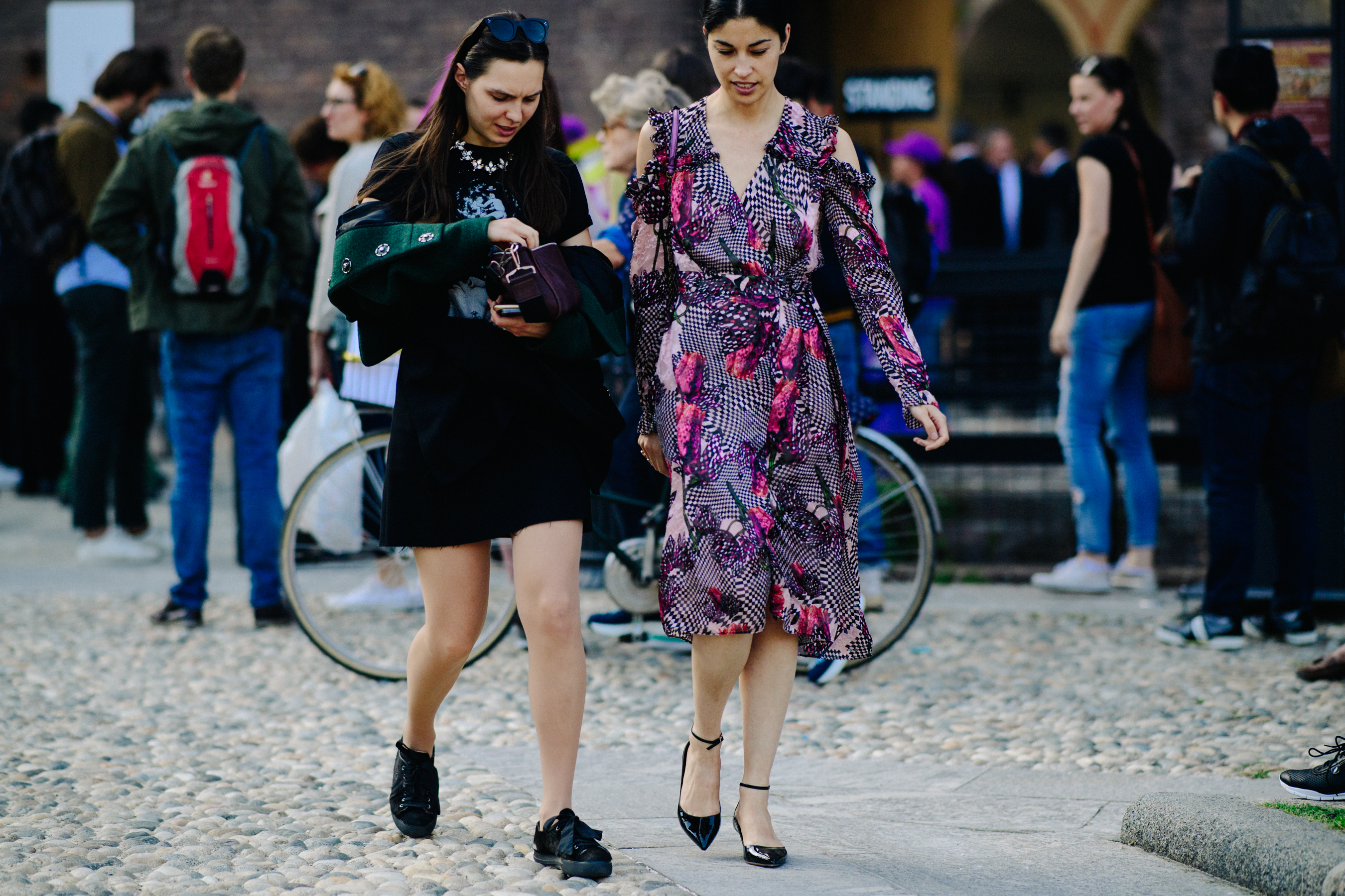 Two women walking in dresses