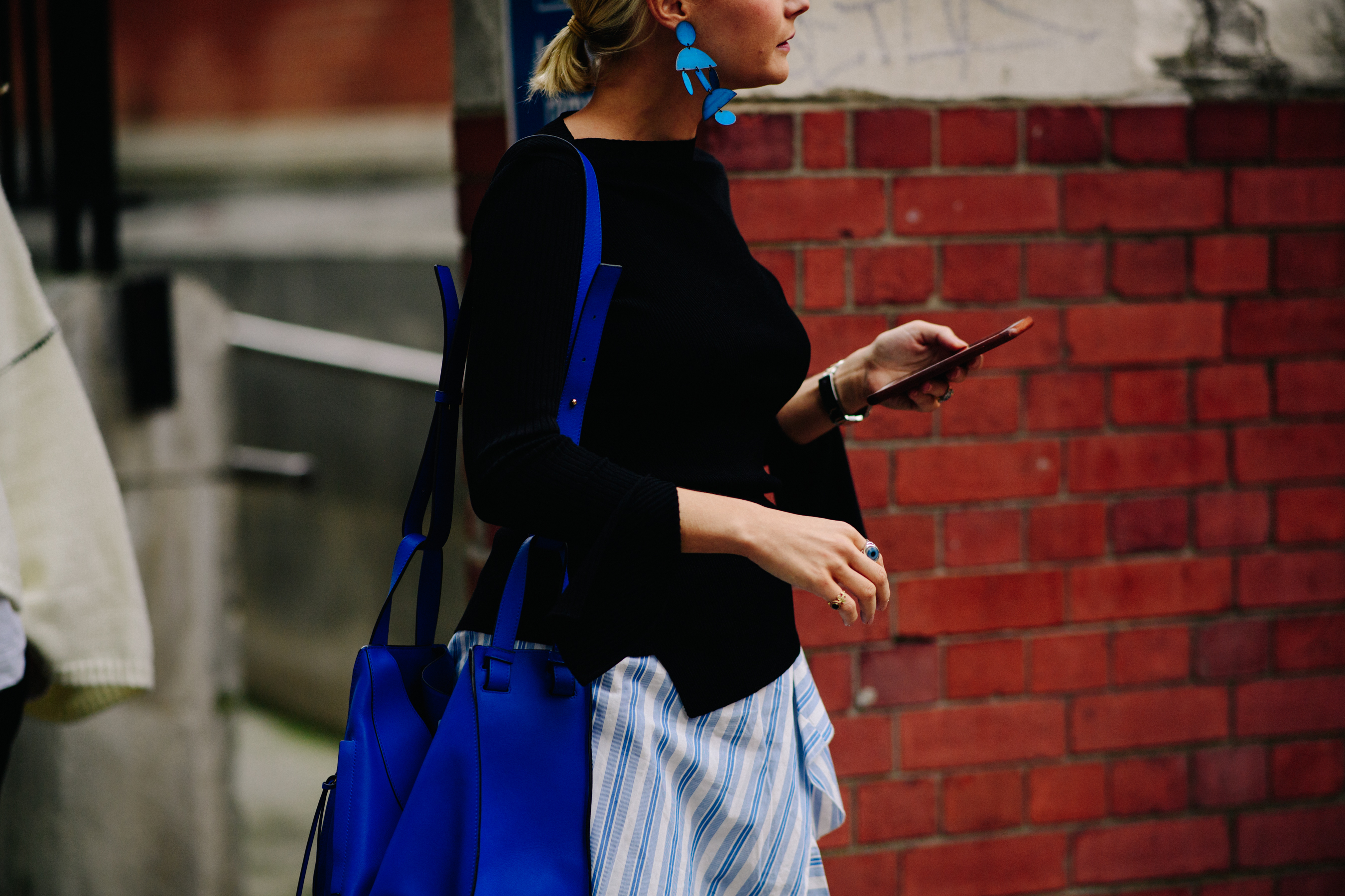 Woman wearing blue bag and earrings